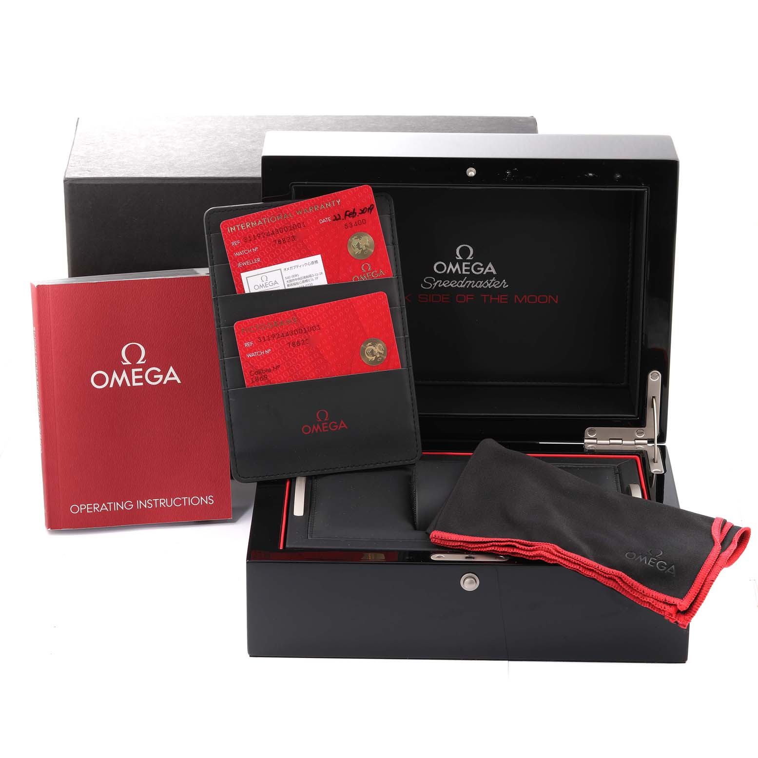 The image shows the Omega Speedmaster 311.92.44.30.01.001 Men
s Ceramic Black Dial 311.92.44.30.01.001 Men
s Ceramic Black Dial accessories, including the box, warranty cards, a manual, and a cleaning cloth.