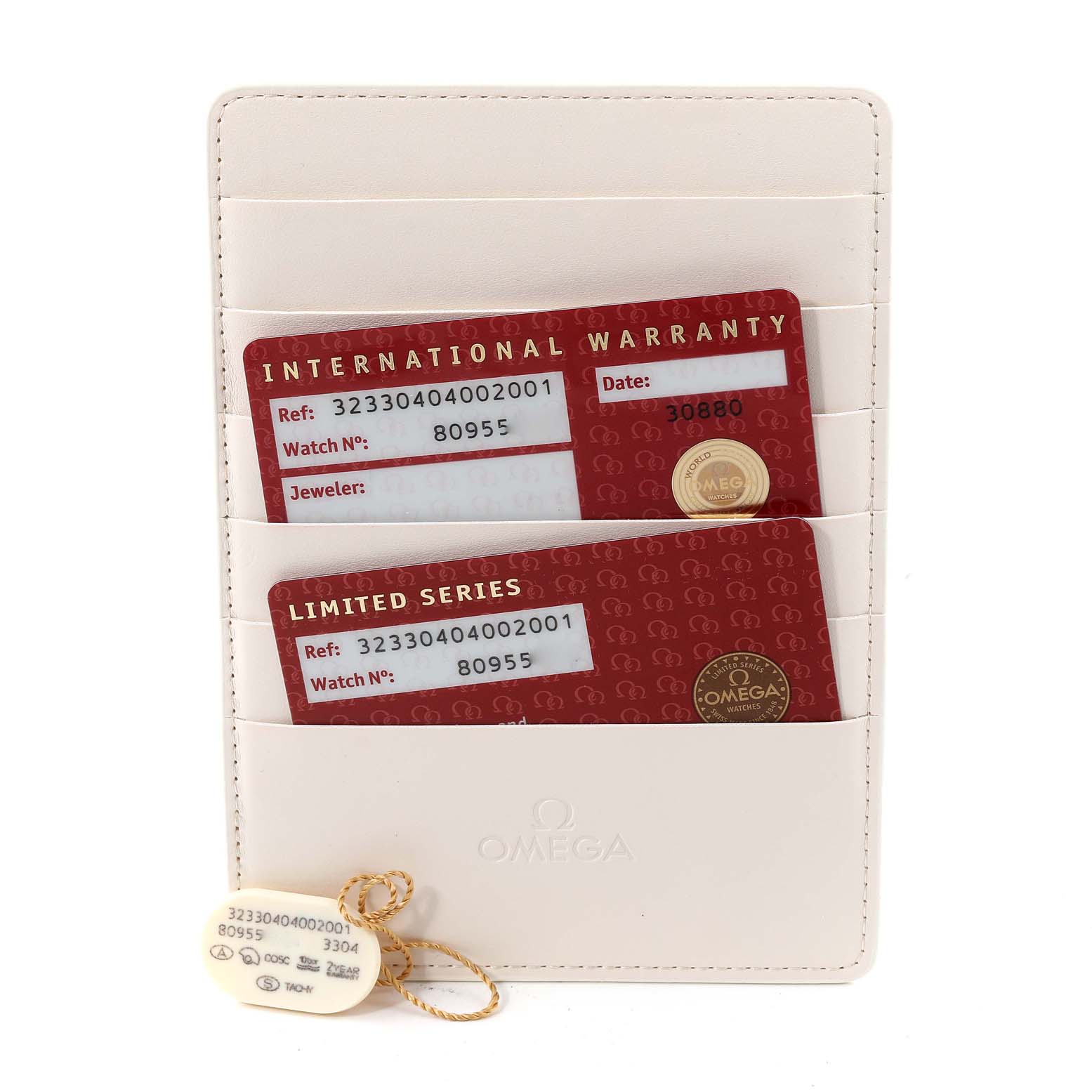 The image shows warranty cards and tags for an Omega Speedmaster 323.30.40.40.02.001 Men's Stainless Steel White Dial 323.30.40.40.02.001 Men's Stainless Steel White Dial watch, placed in a beige cardholder.