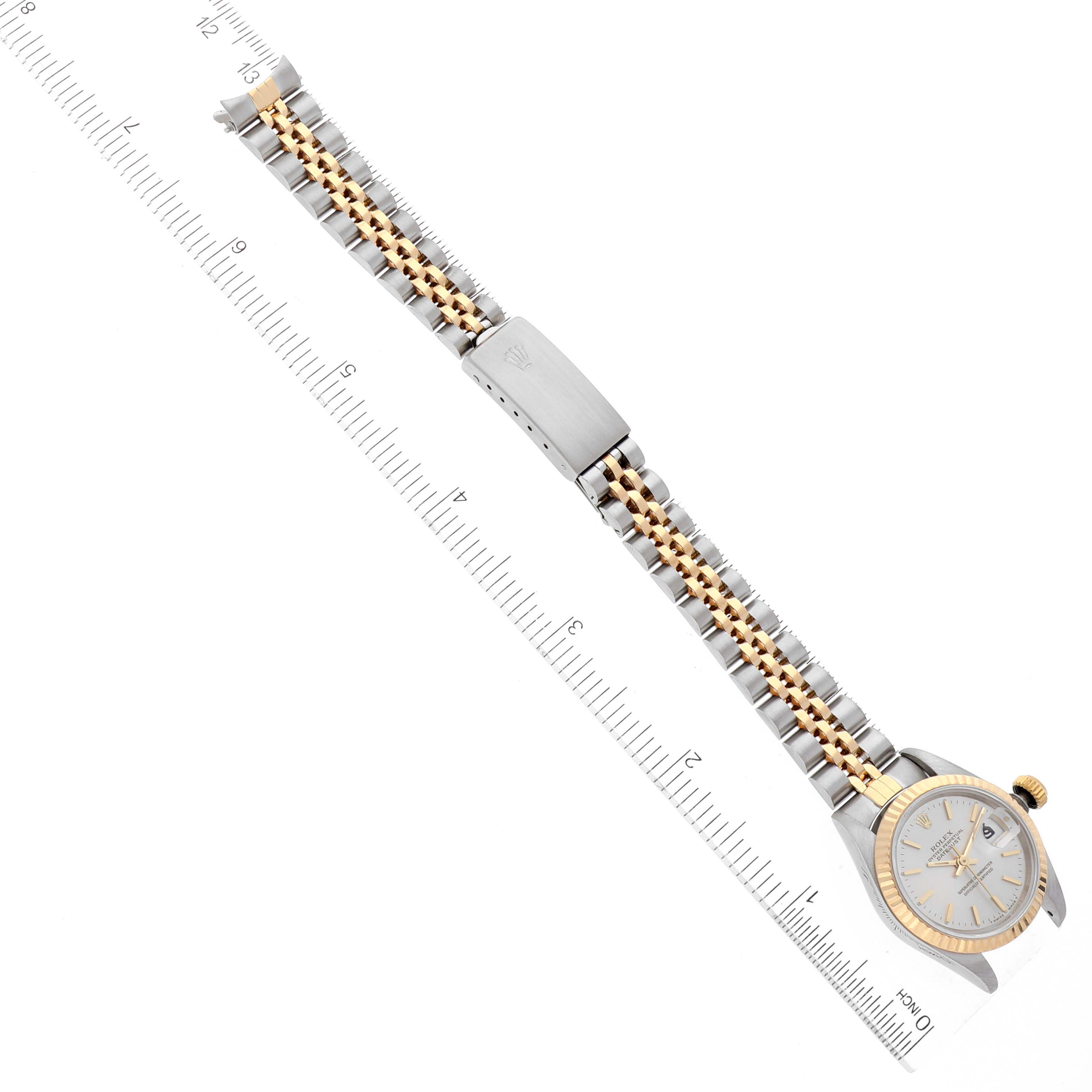 The image shows a Rolex Date 69173 Women's Steel and Gold (two tone) Silver Dial 69173 Women's Steel and Gold (two tone) Silver Dial model watch laid flat, displaying the face, bracelet, and clasp, alongside a measuring ruler.