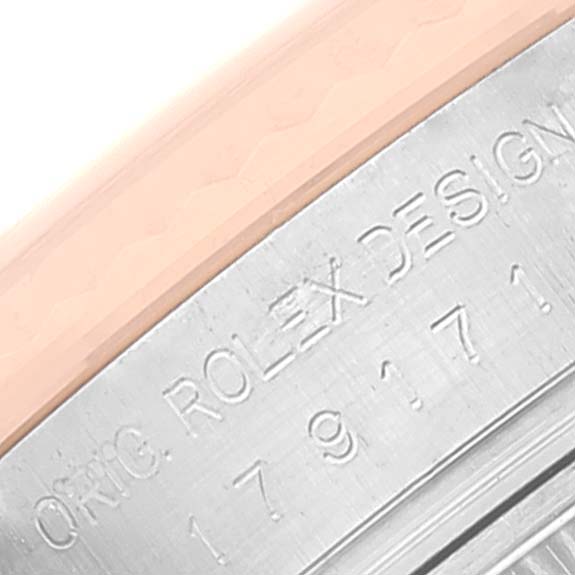 This is a close-up shot of the side of a Rolex Datejust 179171 Women
s Steel and Gold (two tone) Pink Dial 179171 Women
s Steel and Gold (two tone) Pink Dial watch, showcasing the engraved "ROLEX DESIGN" and serial number.