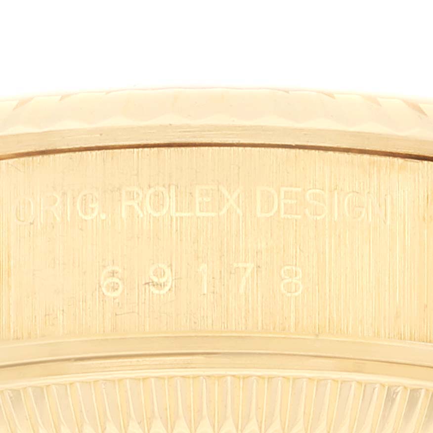 This is a close-up shot of the side of a Rolex President 69178 Women's Yellow Gold Champagne Dial 69178 Women's Yellow Gold Champagne Dial model watch, showing part of the engraving "ORIG. ROLEX DESIGN 69178".