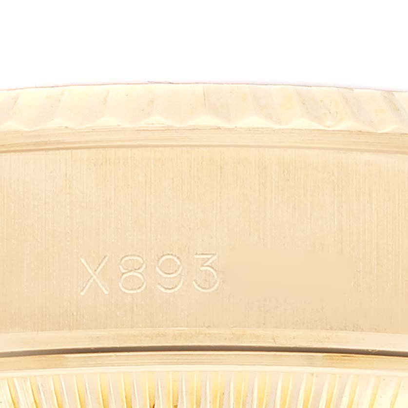 This close-up image of a Rolex President 69178 Women
s Yellow Gold Champagne Dial 69178 Women
s Yellow Gold Champagne Dial watch shows a portion of the case with visible engraving.