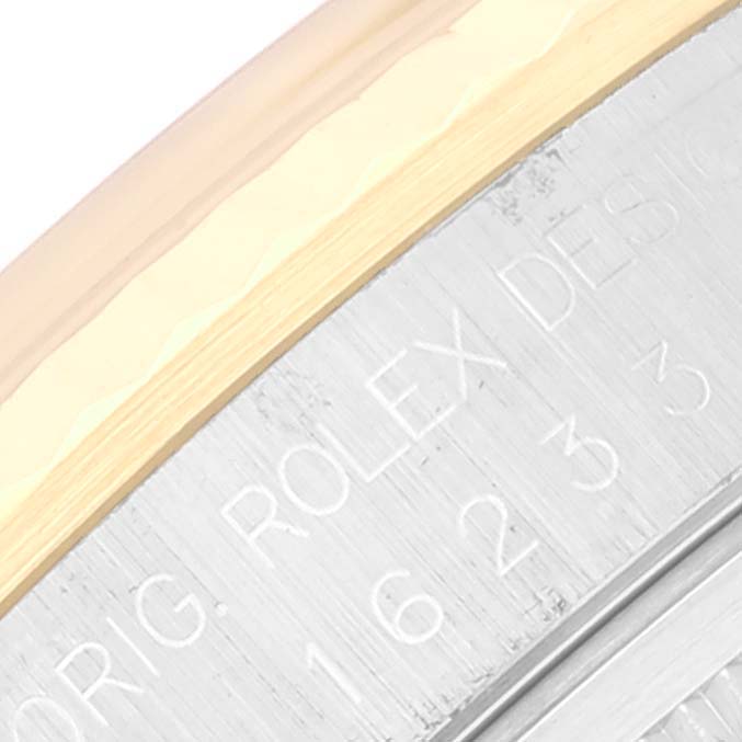The image shows a close-up of the casing, engraving, and bezel of the Rolex Datejust 16233 Men's Steel and Gold (two tone) Champagne Dial 16233 Men's Steel and Gold (two tone) Champagne Dial watch.