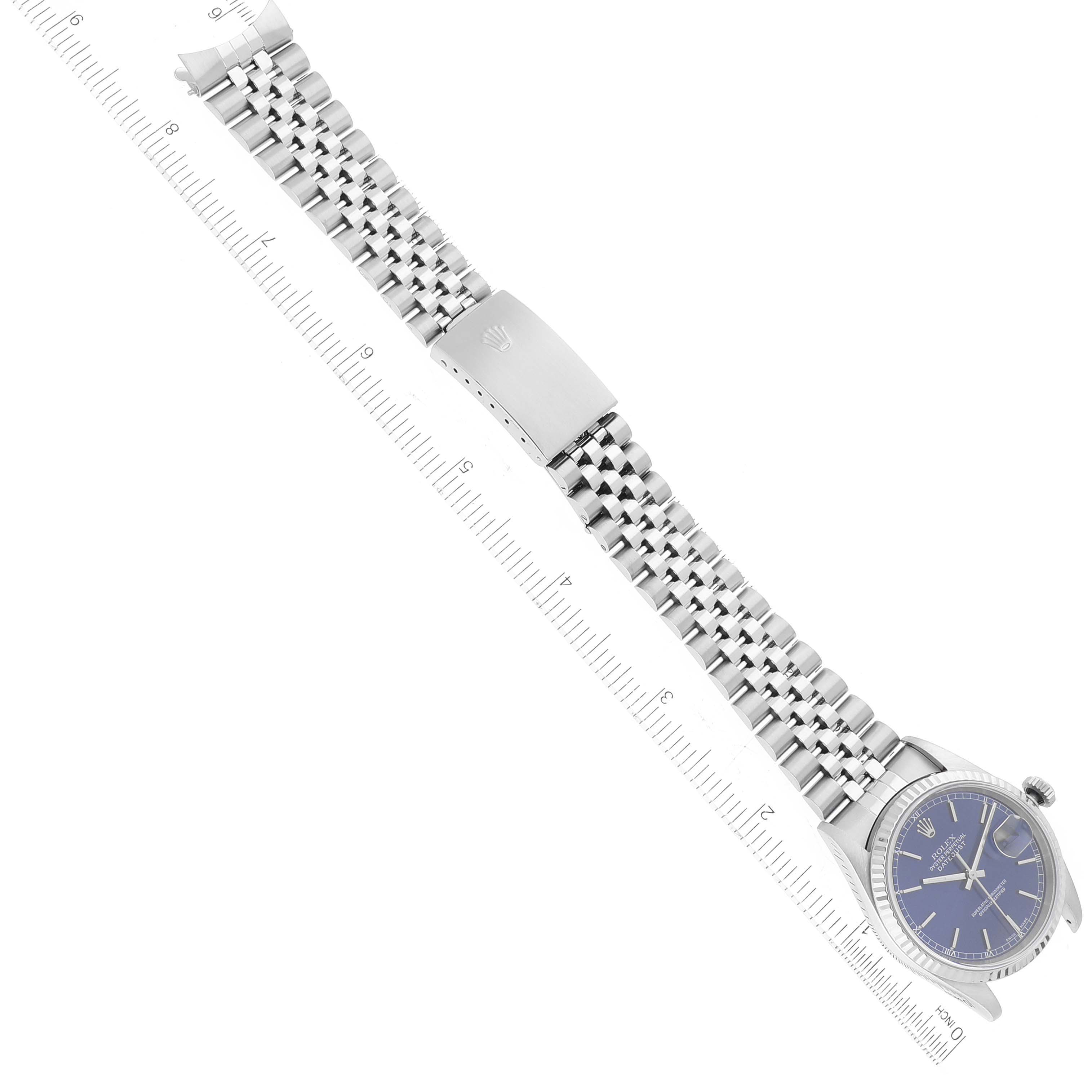 The image shows a top-down view of a Rolex Datejust 16234 Men's Stainless Steel Blue Dial 16234 Men's Stainless Steel Blue Dial watch, displaying the entire face and bracelet next to a ruler for scale.