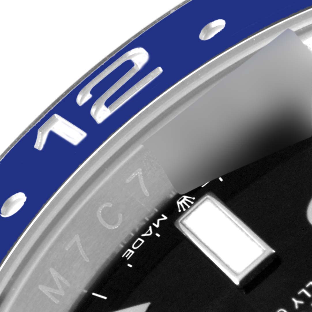 The image shows a close-up of the bezel and part of the dial of a Rolex GMT-Master 126710 Men
s Stainless Steel Black Dial 126710 Men
s Stainless Steel Black Dial watch, featuring the 12-hour numeral.
