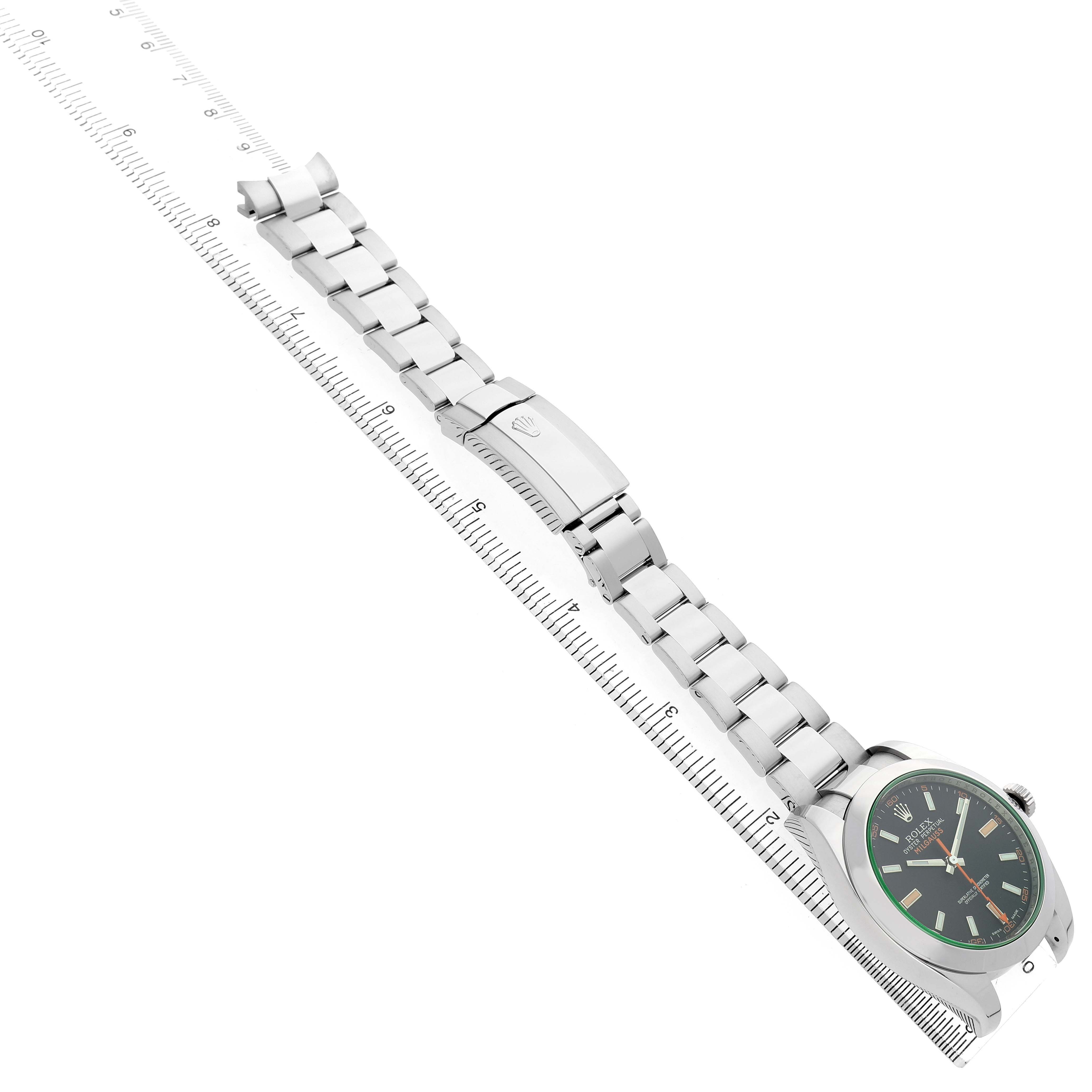 The image shows a side angle of the Rolex Milgauss 116400GV Men's Stainless Steel Black Dial watch, highlighting the face, bracelet, and clasp alongside a ruler for scale.