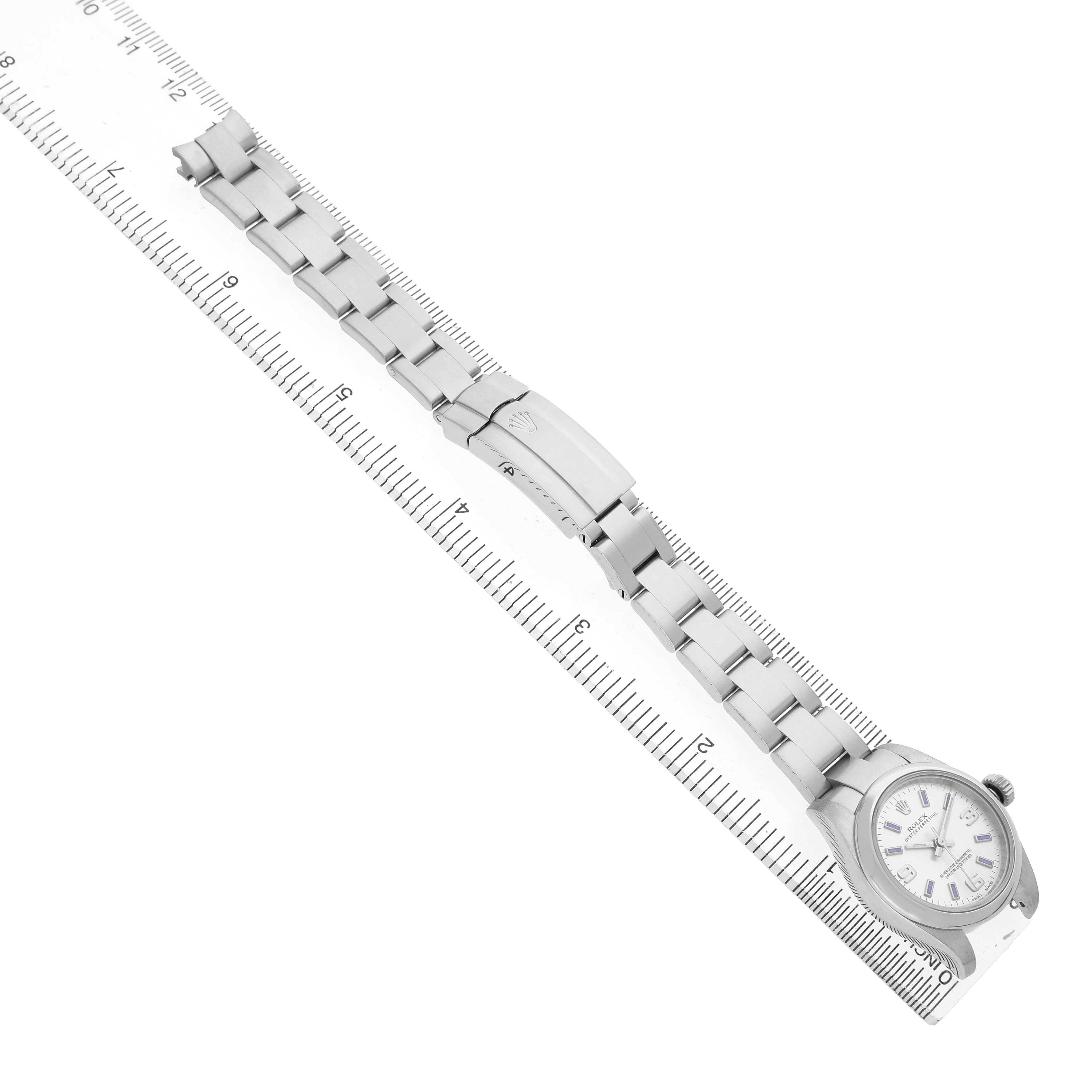 The Rolex Oyster Perpetual 176200 Women's Stainless Steel Silver Dial watch is shown from a top-down angle, featuring the full bracelet and clasp aligned with a ruler.