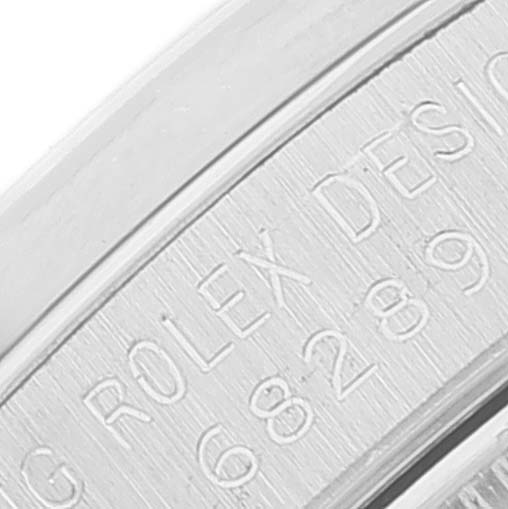The image shows a close-up of the engraved bezel of a Rolex President 68289 Women
s White Gold Silver Dial 68289 Women
s White Gold Silver Dial model watch.