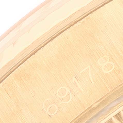 This close-up image shows a part of the case of a Rolex President 69178 Women
s Yellow Gold Champagne Dial 69178 Women
s Yellow Gold Champagne Dial model, highlighting the engraved serial number.