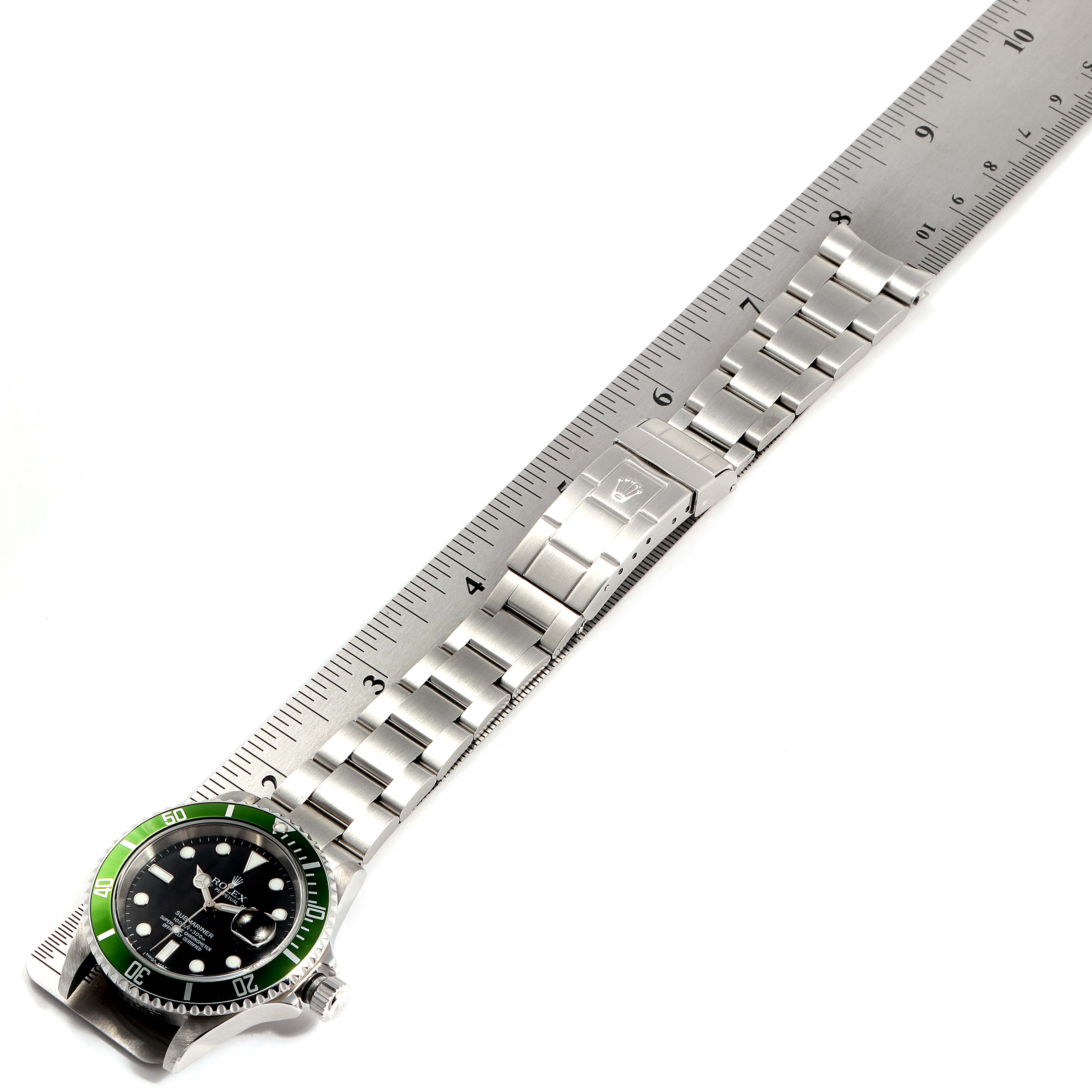 This image shows a Rolex Submariner 16610LV Men
s Stainless Steel Black Dial 16610LV Men
s Stainless Steel Black Dial watch laid flat with a ruler for measurement, showcasing the bracelet and face from a top-down angle.