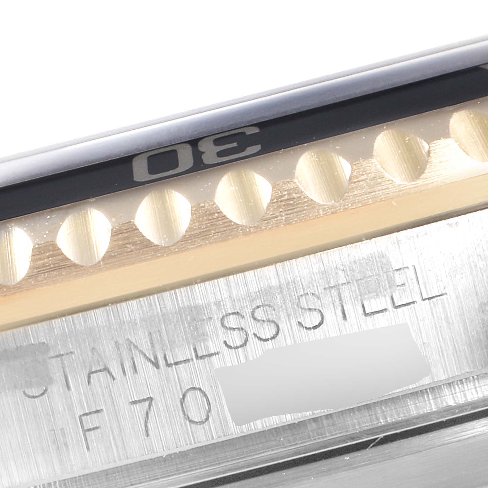 This close-up image of the Rolex Submariner 16613 Men's Steel and Gold (two tone) Black Dial 16613 Men's Steel and Gold (two tone) Black Dial shows part of the bezel and the stainless steel case engraving.