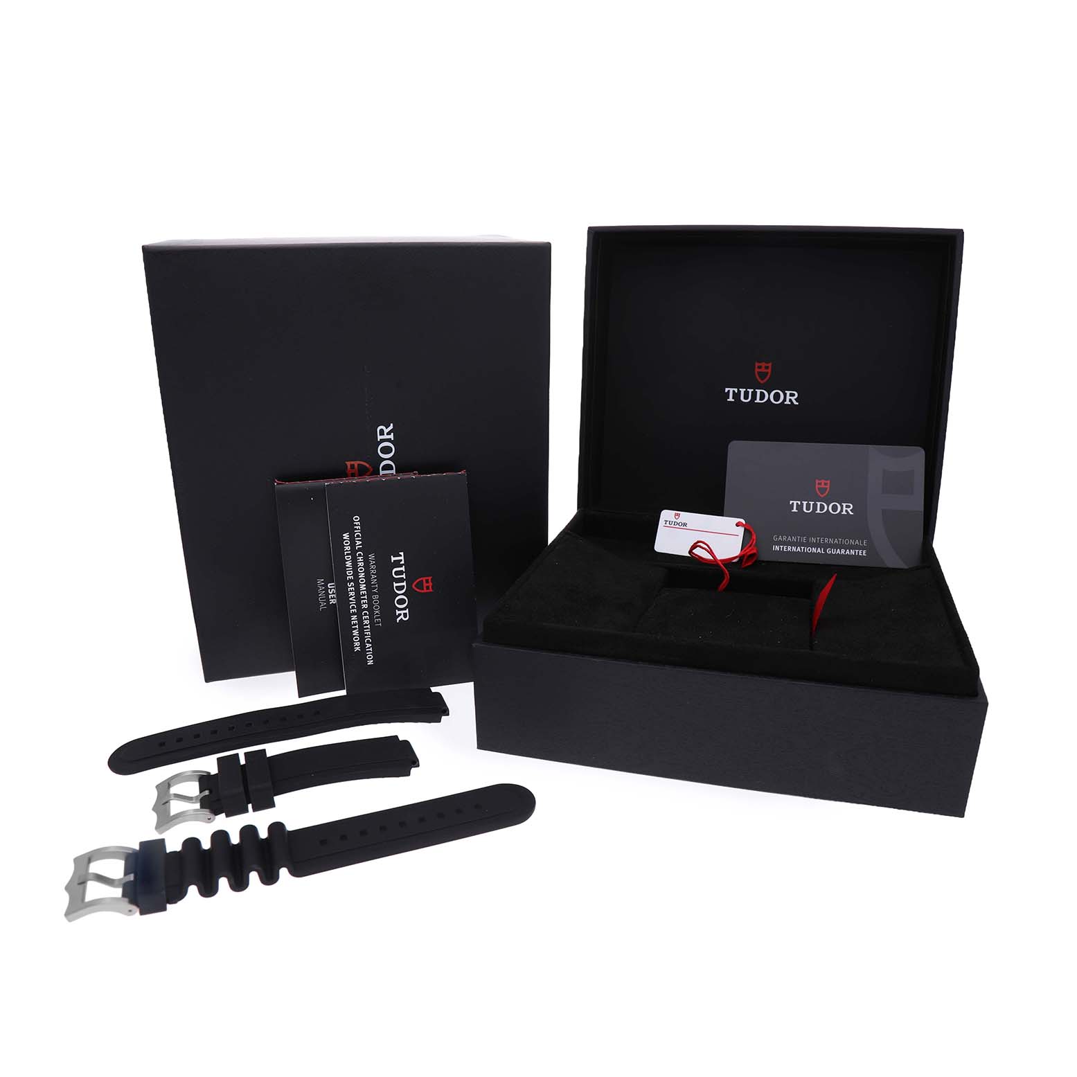 The image shows packaging for a Tudor Pelagos 25600TN Men's Titanium Black Dial watch, with additional straps, warranty card, and manuals.