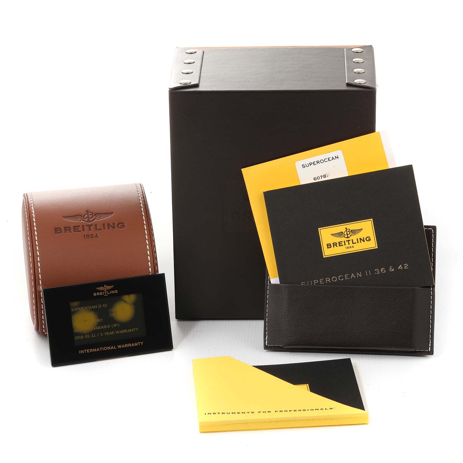 The image shows accessories for the Breitling Superocean A17365 Men's Stainless Steel Blue Dial A17365 Men's Stainless Steel Blue Dial, including the box, warranty card, manuals, and document holder, from a front angle.