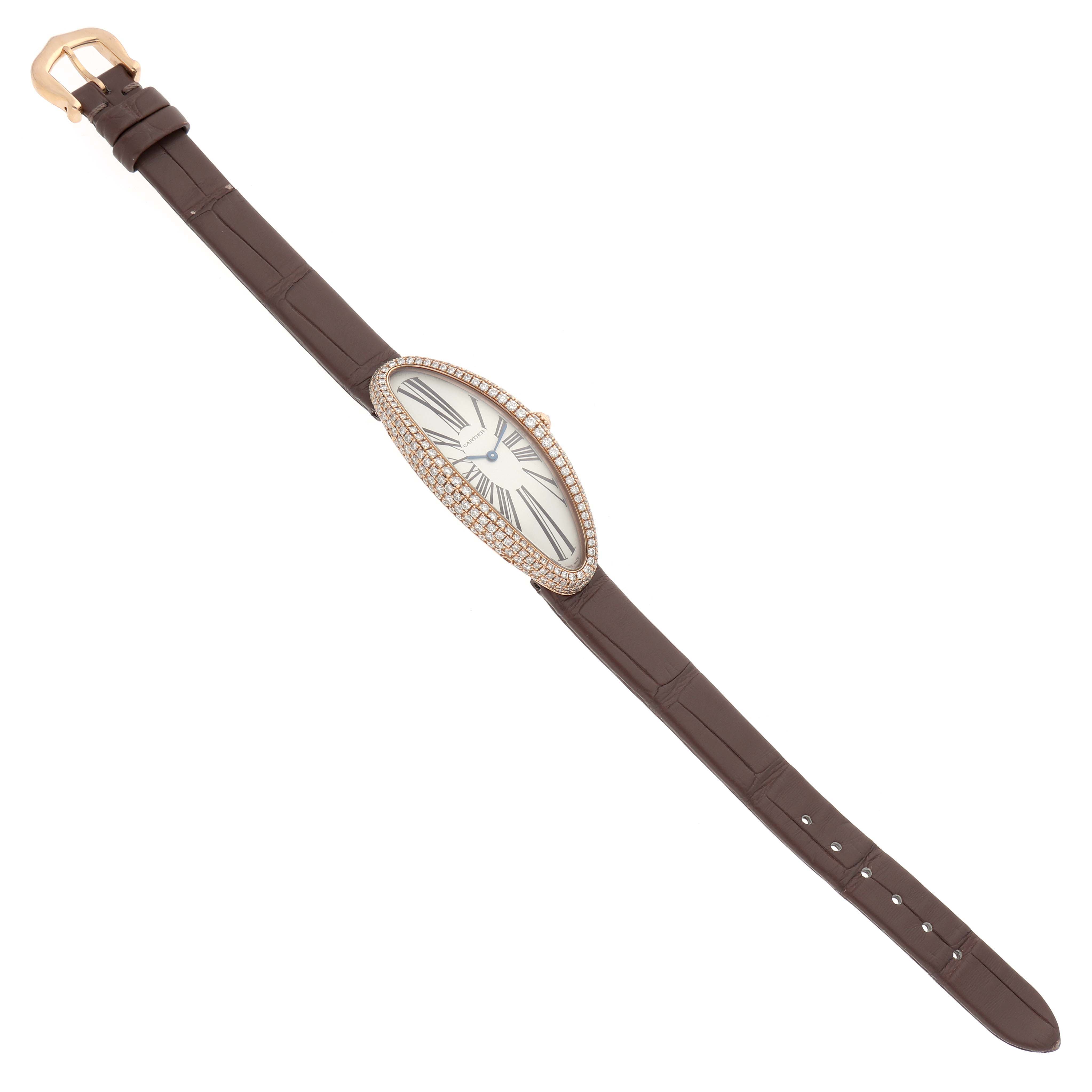 The image shows the Cartier Baignoire WJBA0006 Women's Rose Gold Silver Dial watch at an angled top view, highlighting its oval dial, diamond bezel, and brown leather strap.