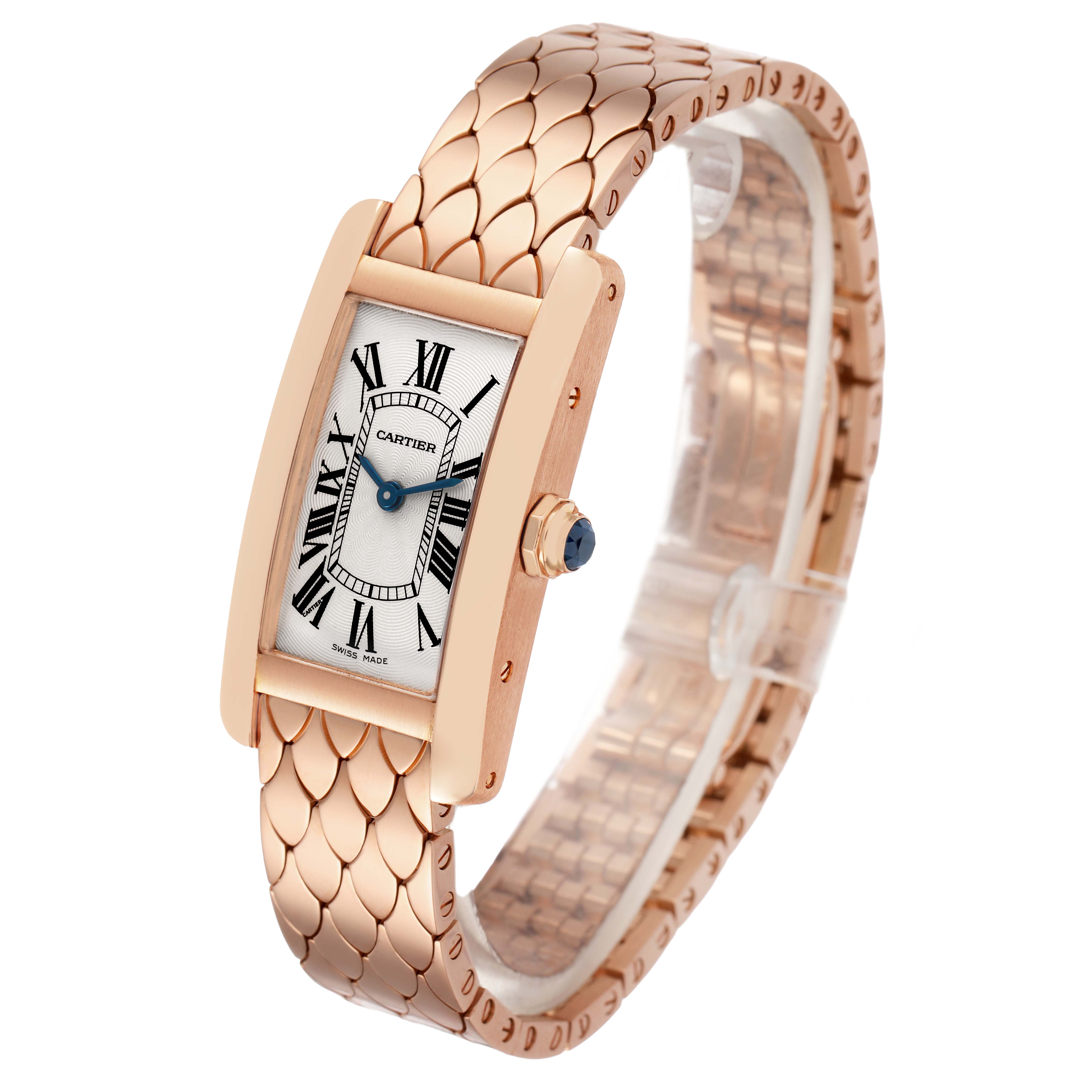 The Cartier Tank Américaine watch is shown at a three-quarter angle, displaying its face, bracelet, and crown with a blue cabochon.