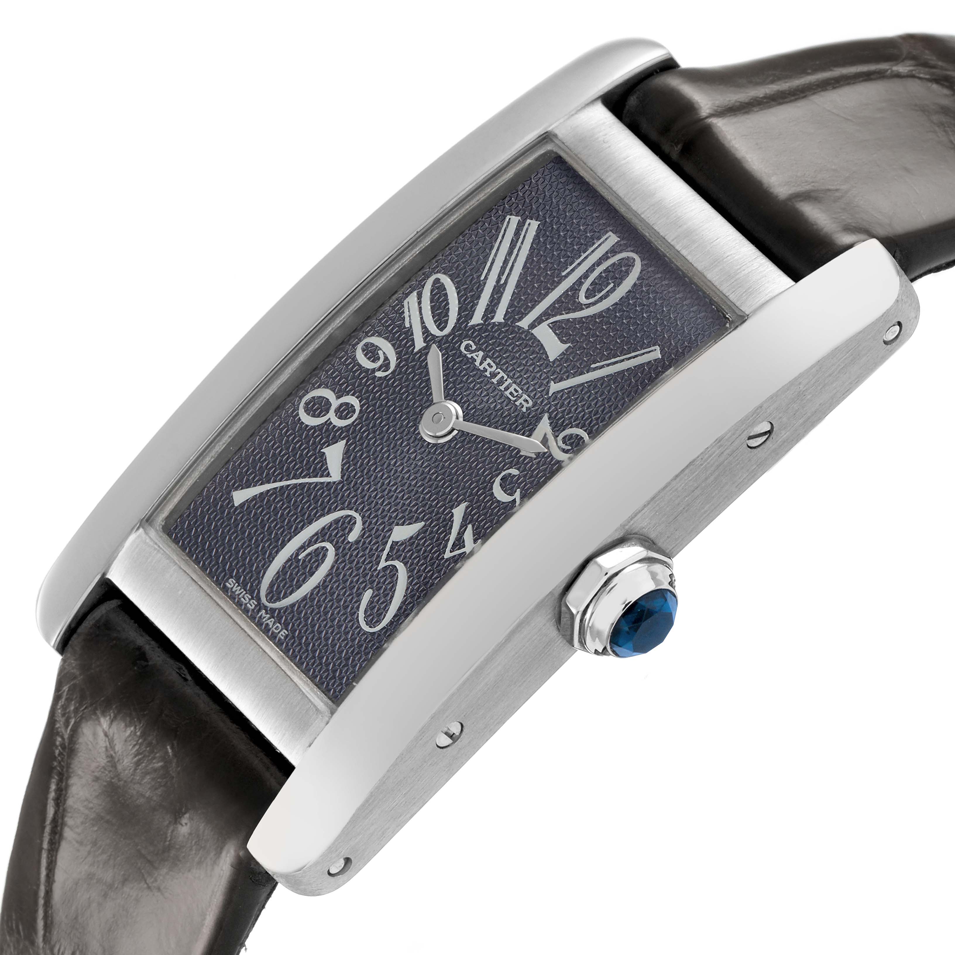 The Cartier Tank Américaine watch is shown at an angled side view, highlighting the crown with a blue gem and leather strap.