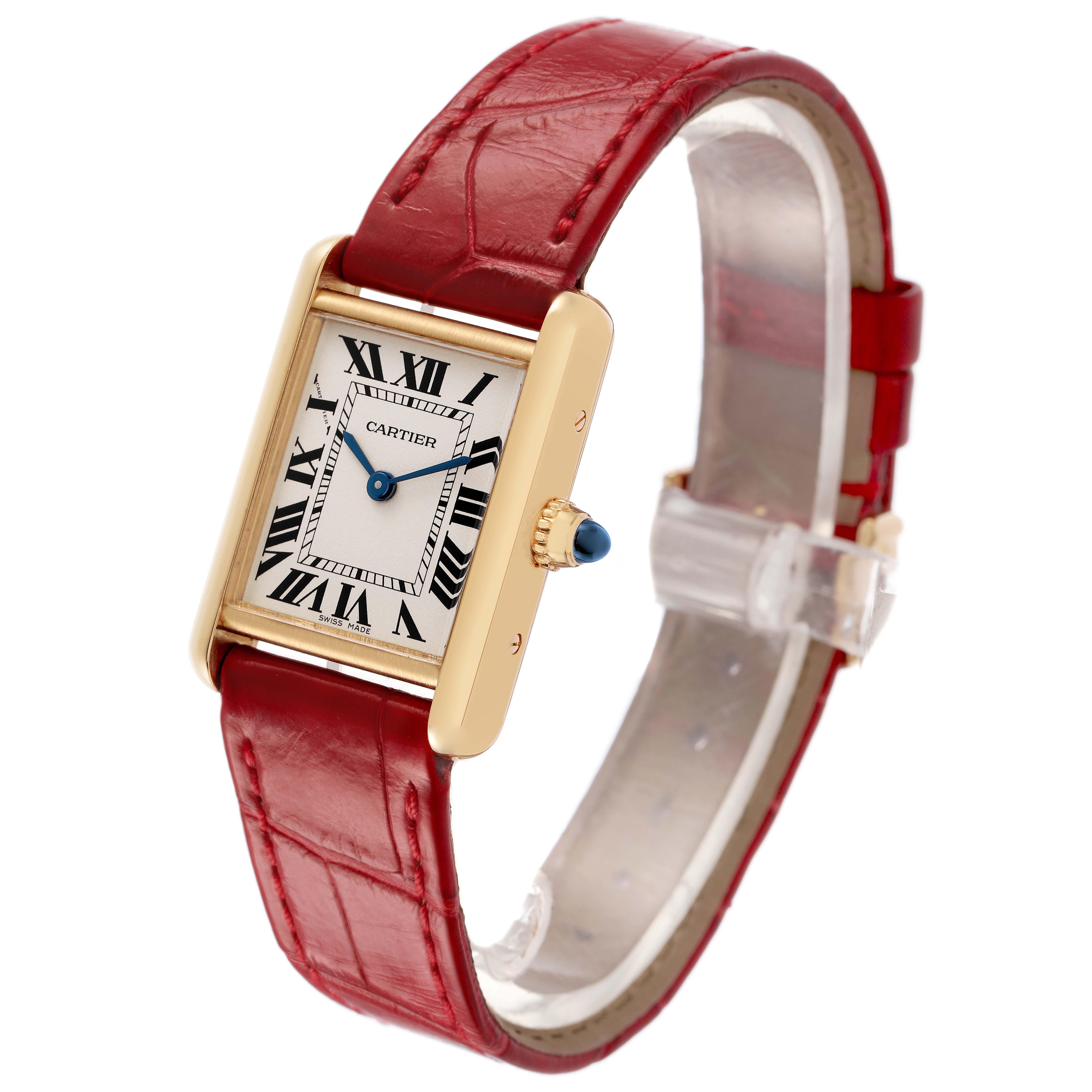 The Cartier Tank Louis W1529856 Women's Yellow Gold Silver Dial watch is shown from a three-quarter angle, highlighting its red strap, rectangular gold case, and blue cabochon crown.