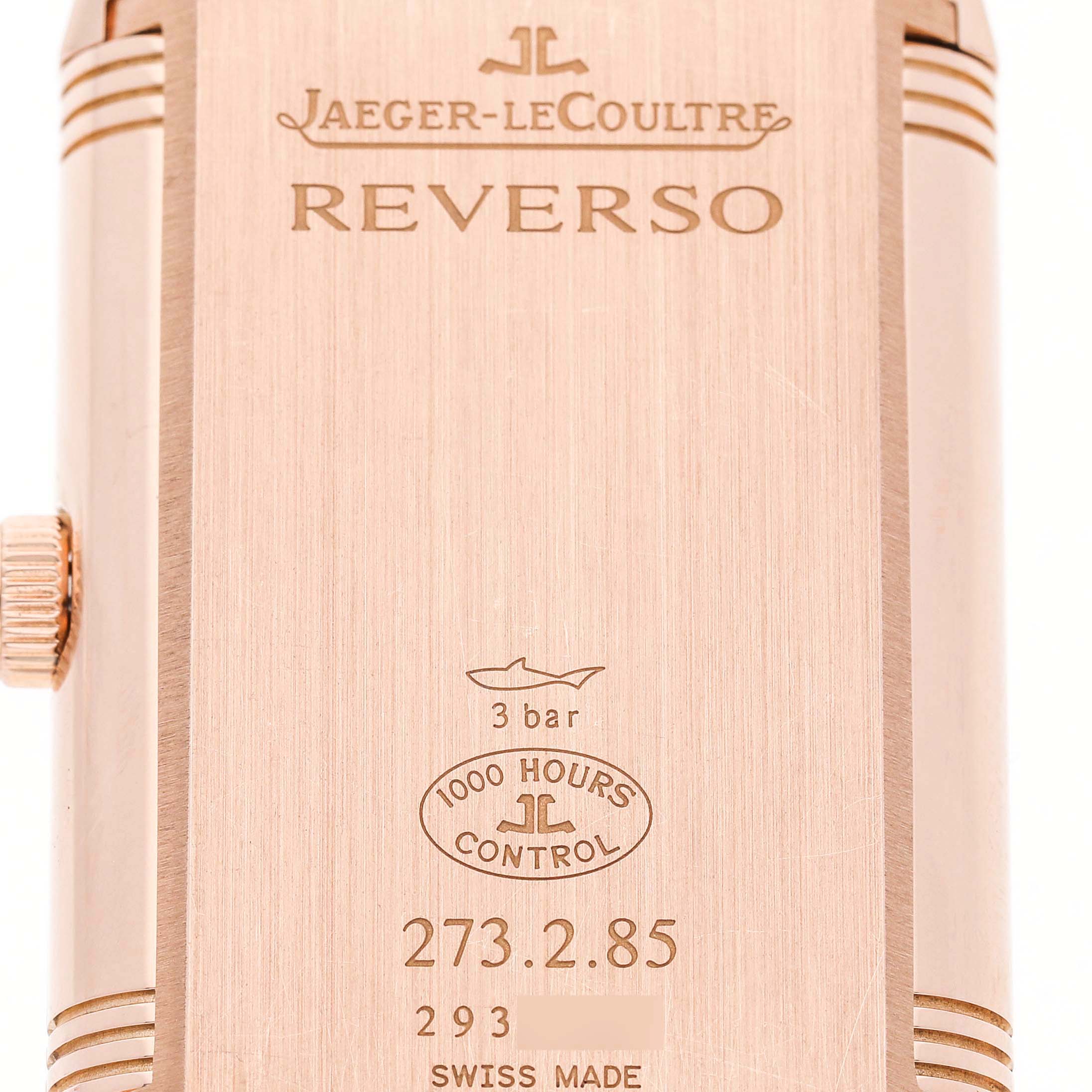 The image shows the back of the Jaeger-LeCoultre Reverso watch, highlighting engravings and the crown.