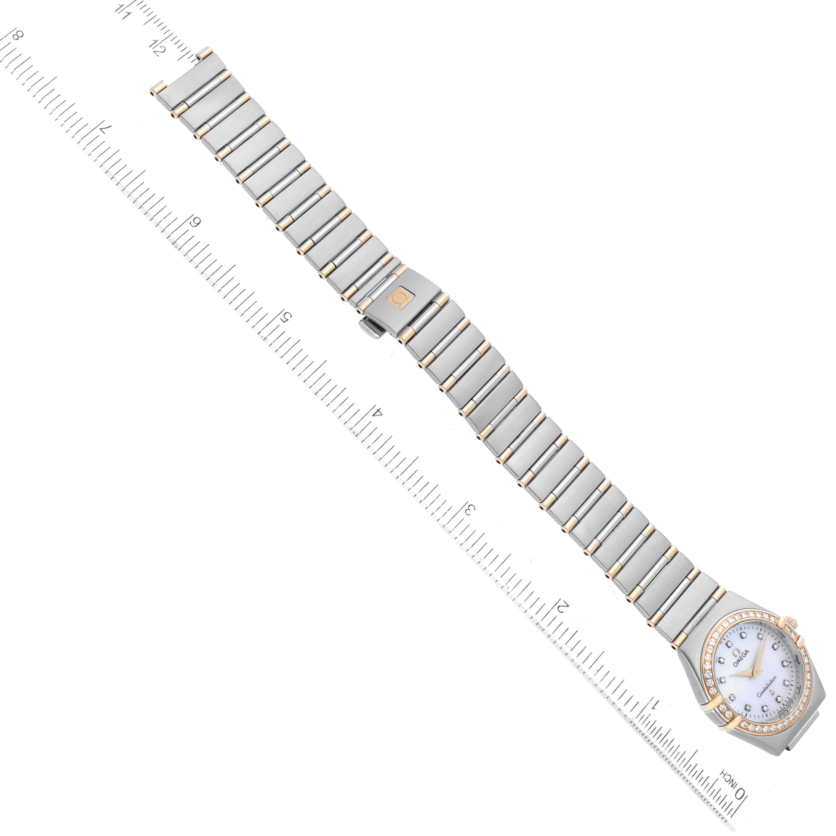 This image shows the Omega 1267.75.00 Women's Steel and Gold (two tone) Mother of Pearl Dial 1267.75.00 Women's Steel and Gold (two tone) Mother of Pearl Dial Constellation 95 MOP Diamond Yellow Gold Steel Ladies Watch 1267.75.00 laid flat with a ruler for scale.