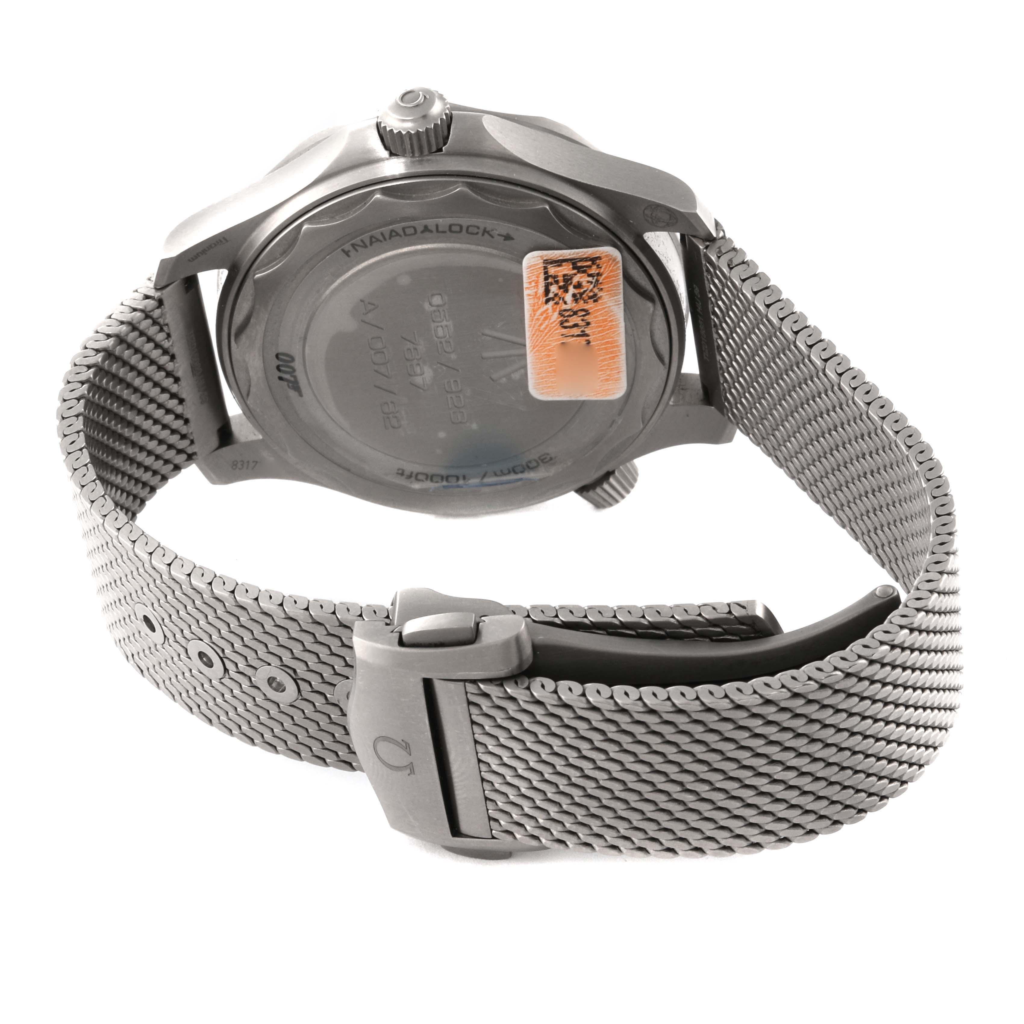 The image shows the back view of an Omega Seamaster 210.92.42.20.01.001 Men's Titanium Brown Dial 210.92.42.20.01.001 Men's Titanium Brown Dial watch, highlighting its case back, crown, and mesh bracelet.