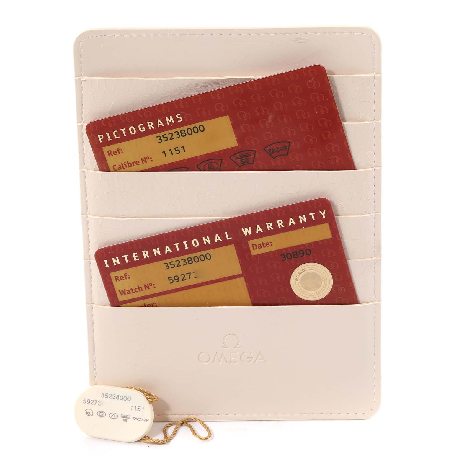 The image shows warranty and pictogram cards along with a tag for the Omega Speedmaster 3523.80.00 Men
s Stainless Steel Blue Dial 3523.80.00 Men
s Stainless Steel Blue Dial, placed in a beige cardholder.