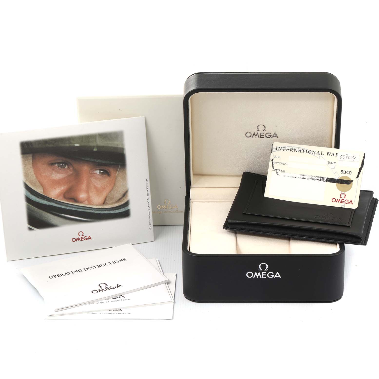 The image shows the packaging and accessories for an Omega Speedmaster 3517.30.00 Men's Stainless Steel Silver Dial 3517.30.00 Men's Stainless Steel Silver Dial, including the box, warranty card, and operating instructions.