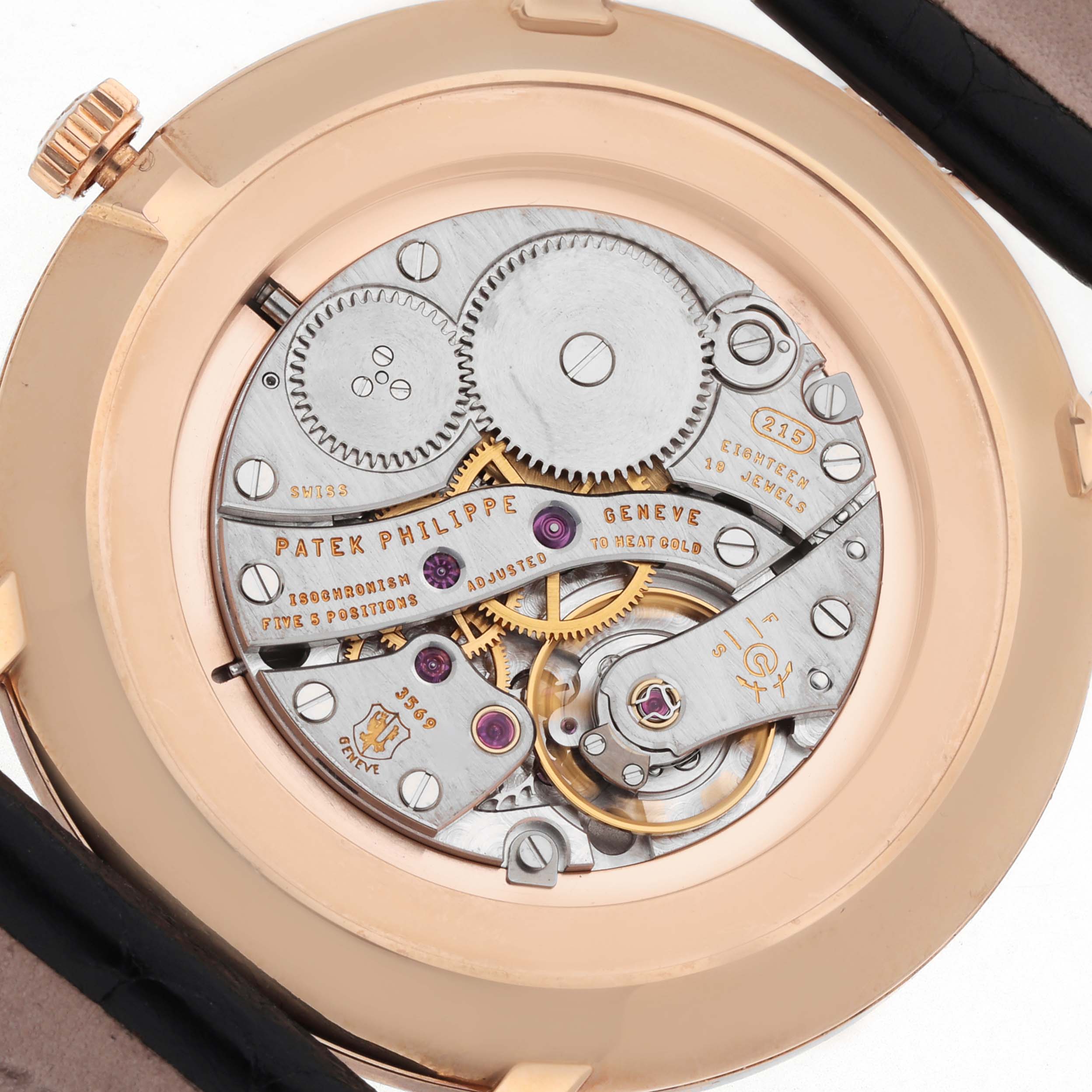 The image shows the intricate back view of the Patek Philippe Calatrava 5119R Men's Rose Gold White Dial, highlighting its mechanical movement and gears.