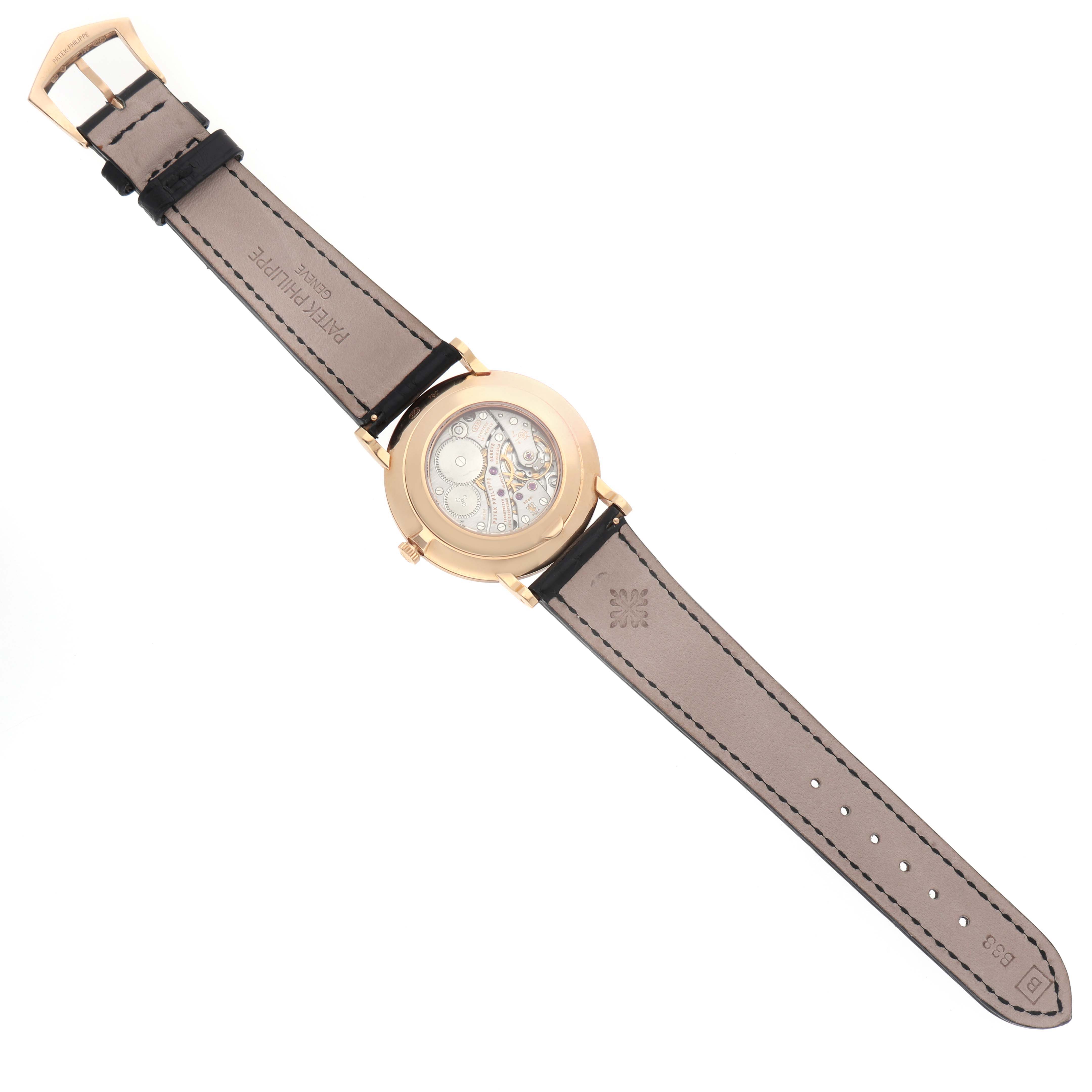 The image shows the back view of a Patek Philippe Calatrava 5119R Men's Rose Gold White Dial watch, displaying the movement and leather strap.