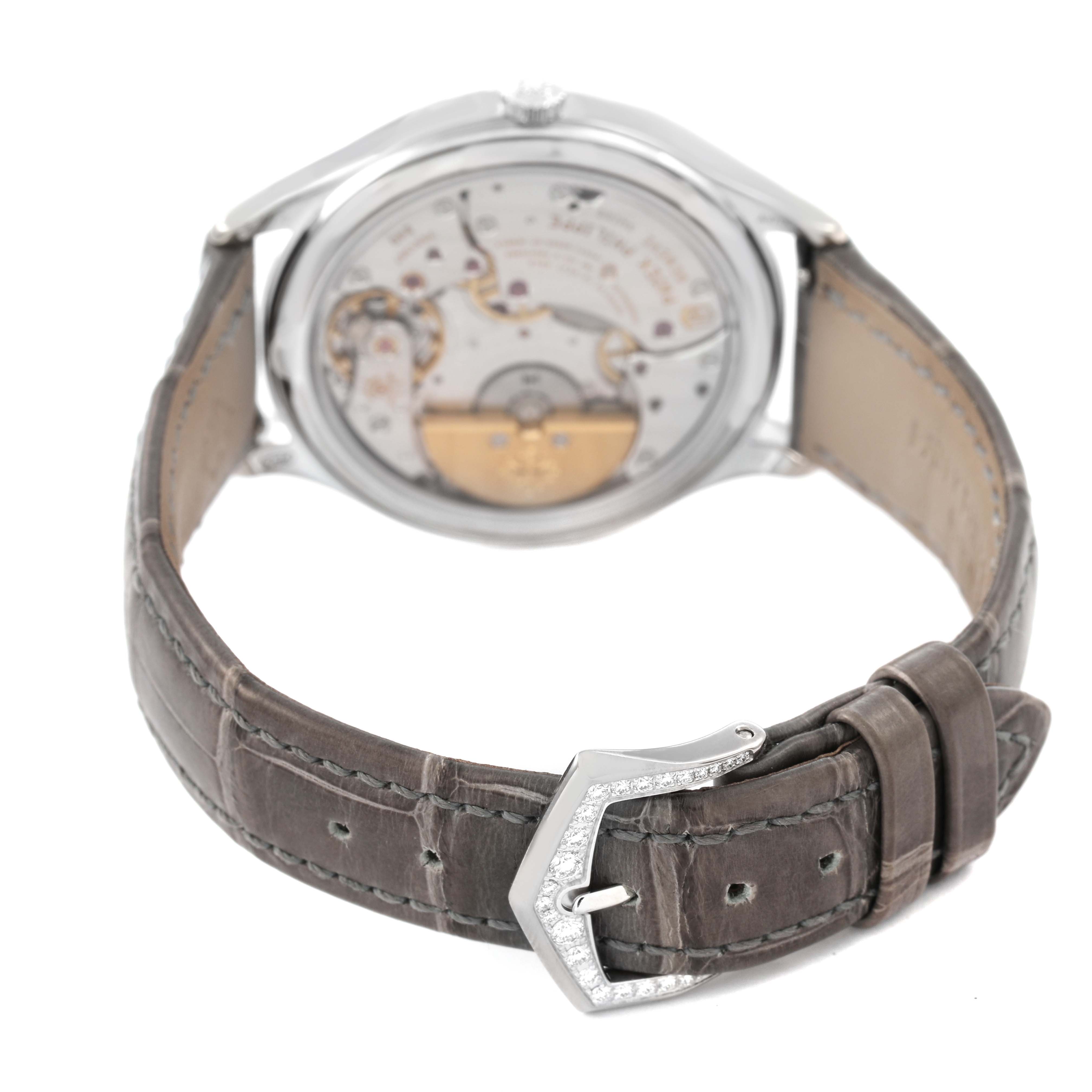 The image shows the back of a Patek Philippe Complications 7140G-001 Women's White Gold Silver Dial watch, highlighting the mechanical movement and buckle of the leather strap.