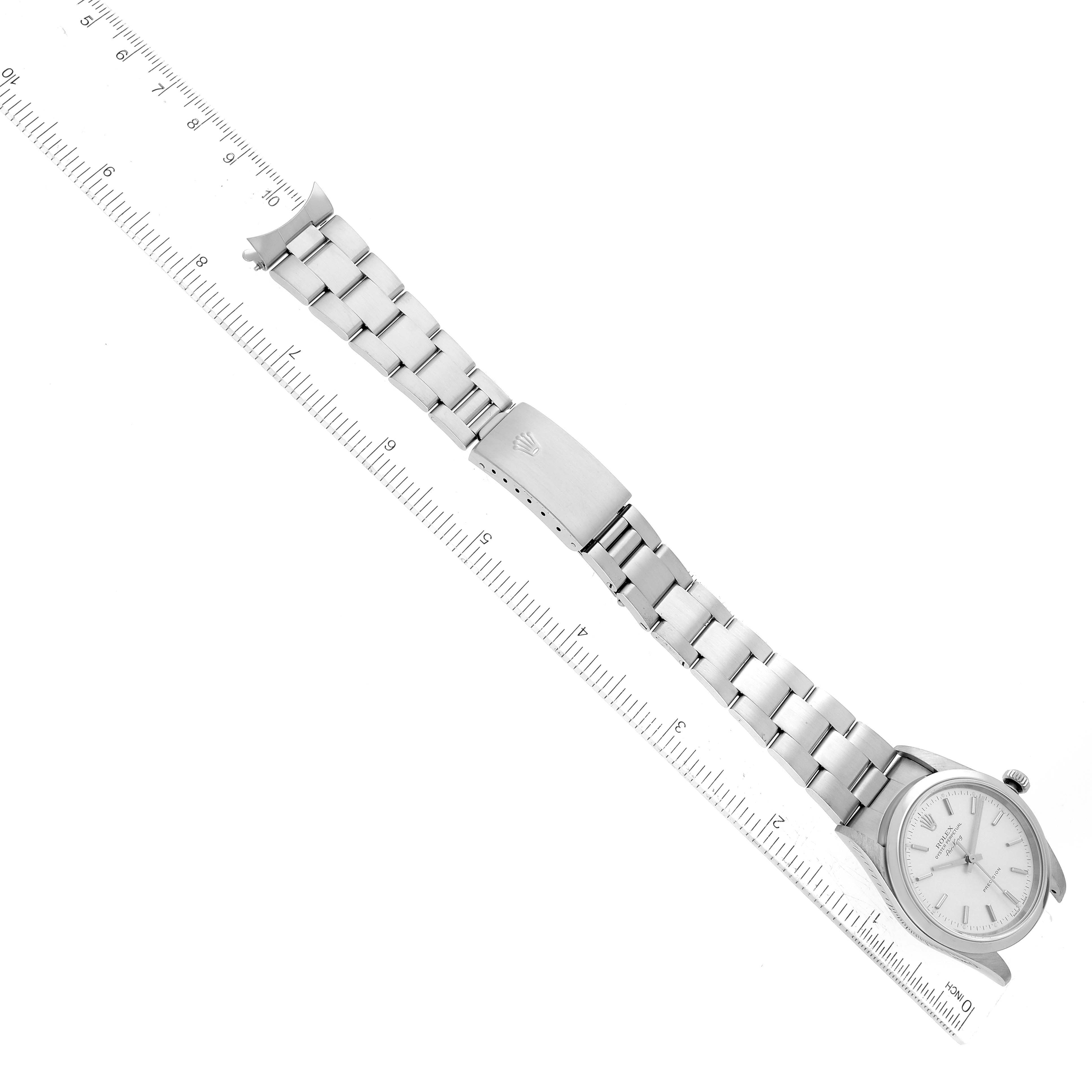 This top-down view shows the full length of the Rolex Air-King 14000M Men's Stainless Steel Silver Dial 14000M Men's Stainless Steel Silver Dial watch including the face, bracelet, and clasp, with a ruler for scale.