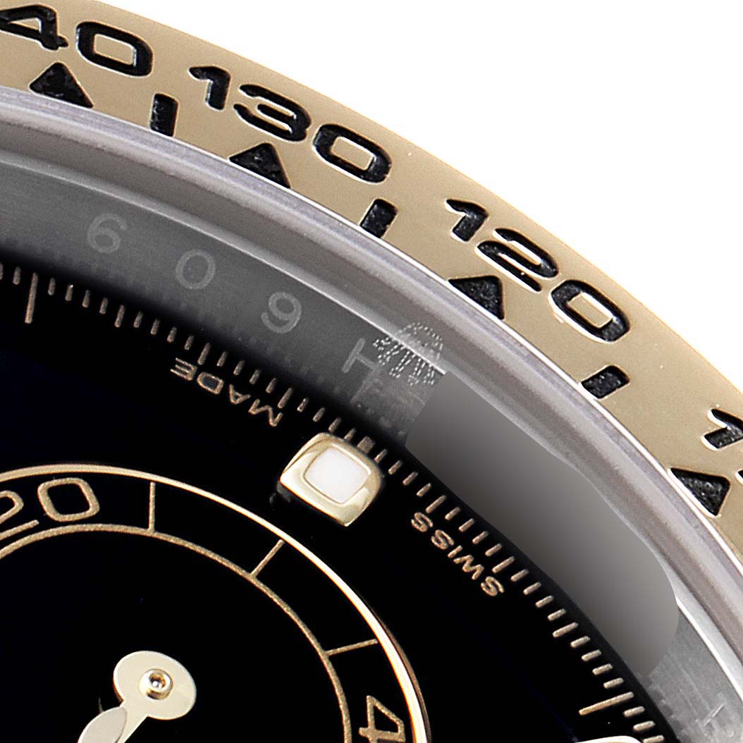 Close-up of the bezel and part of the dial of a Rolex Daytona 116503 Men's Steel and Gold (two tone) Black Dial 116503 Men's Steel and Gold (two tone) Black Dial watch, showcasing its tachymeter scale and subdial markings.