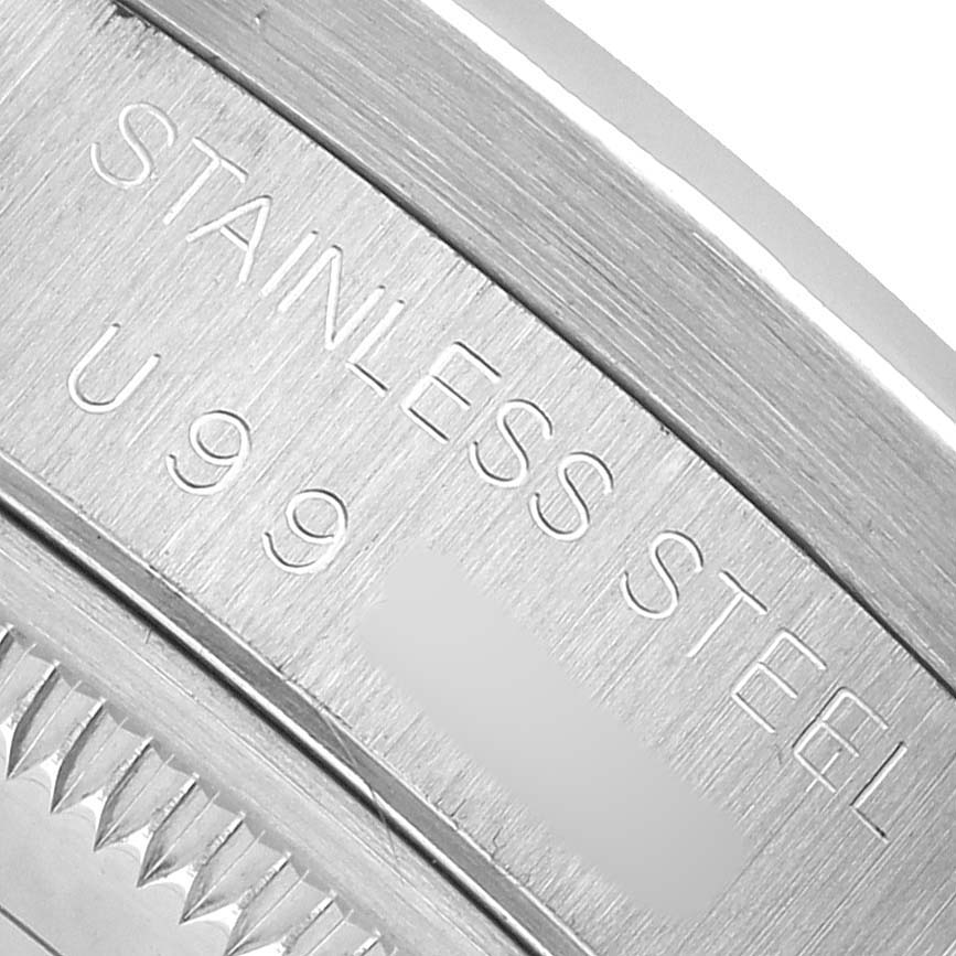 This image shows the engraved side of the bezel of a Rolex Date 15210 Men's Stainless Steel Silver Dial model, highlighting "STAINLESS STEEL" and part of the reference number.