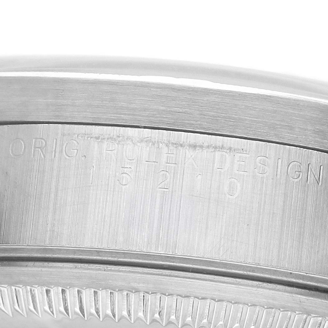 The image shows a close-up of the edge and brushed surface of a Rolex Date 15210 Men's Stainless Steel White Dial model's case with engraved text.
