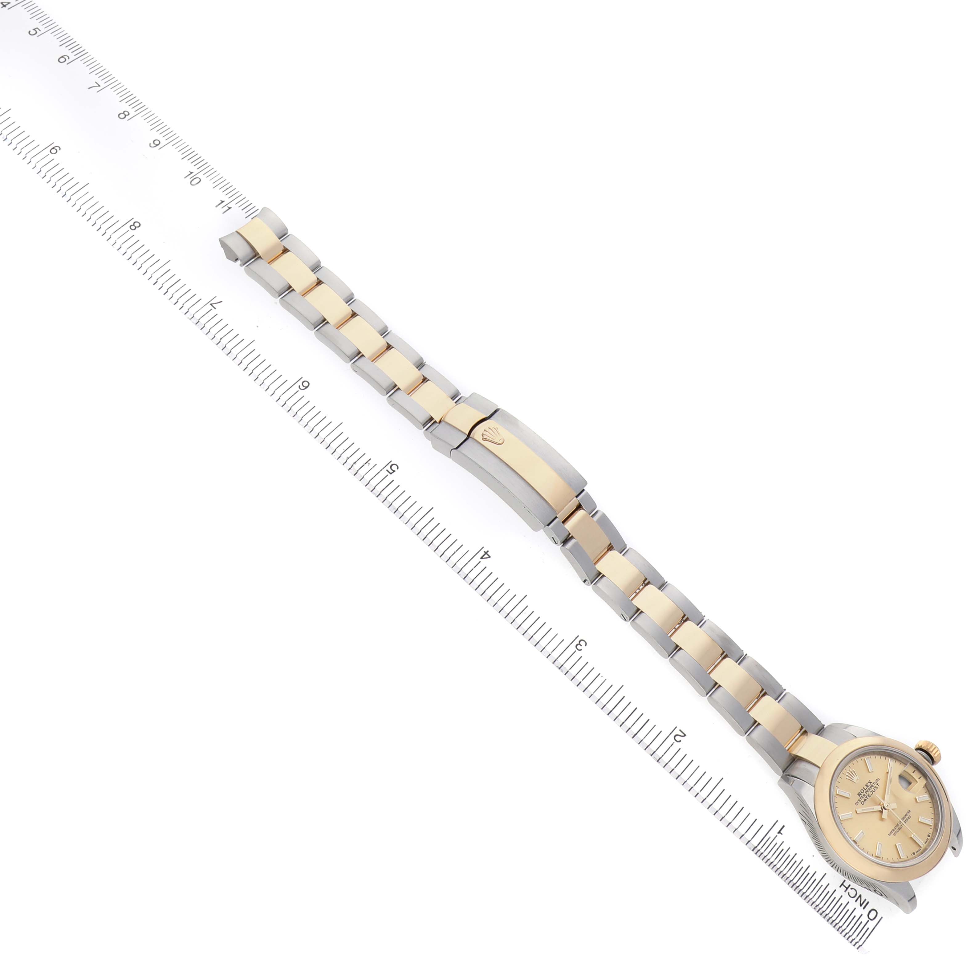 The image shows a Rolex Datejust 279173 Women's Stainless Steel Champagne Dial watch at a slight angle, highlighting its dial, bracelet, and clasp alongside a ruler.