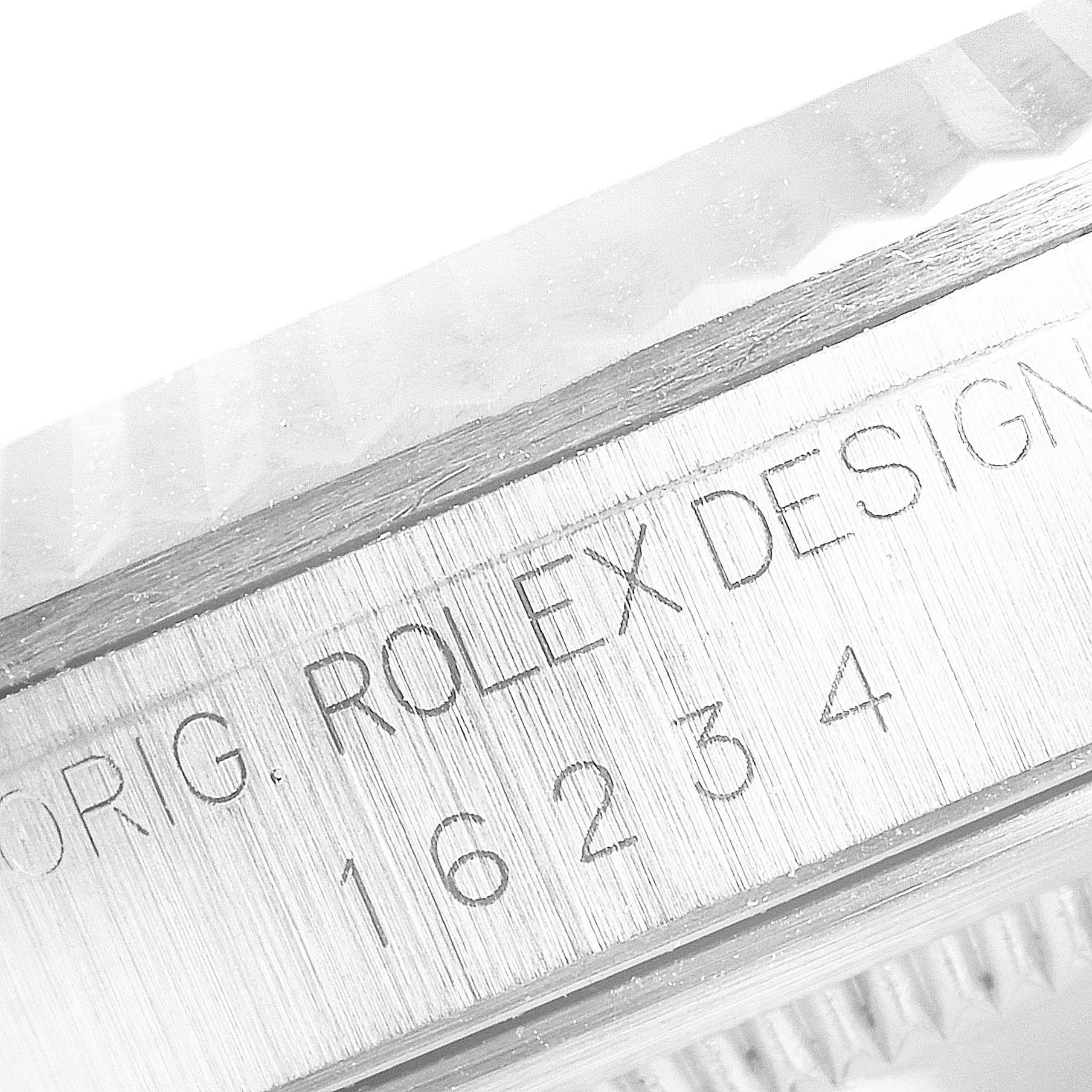 The image shows a close-up of the case side engraving of a Rolex Datejust 16234 Men's Stainless Steel White Dial 16234 Men's Stainless Steel White Dial watch, focusing on the serial number and "ROLEX DESIGN" text.