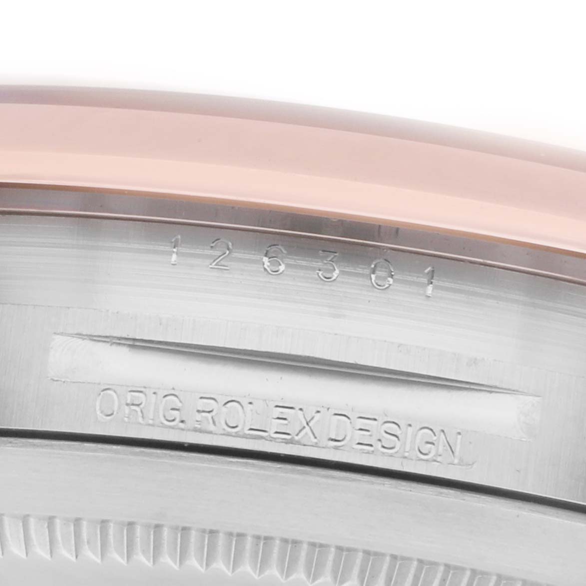 The image shows a close-up of the side of a Rolex Datejust 41 126301 Men
s Steel and Gold (two tone) Pink Dial, focusing on the engraved serial and design numbers.