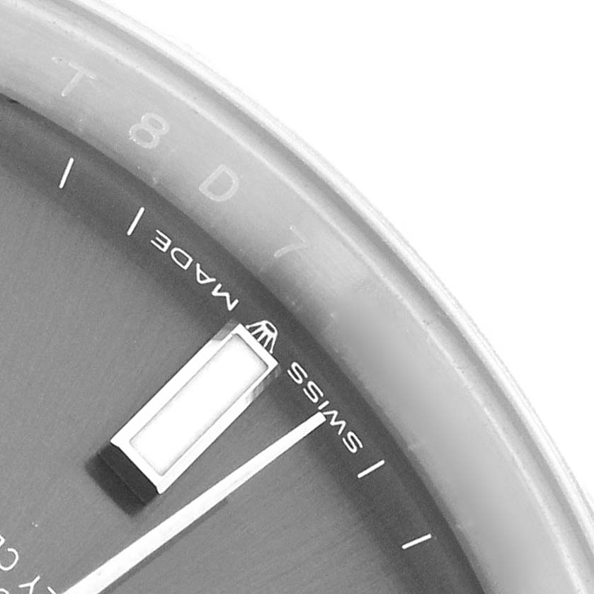 The image shows a close-up of the Rolex Datejust 126300 Men
s Stainless Steel Grey Dial watch face, highlighting the bezel, part of the dial, and a rectangular hour marker.