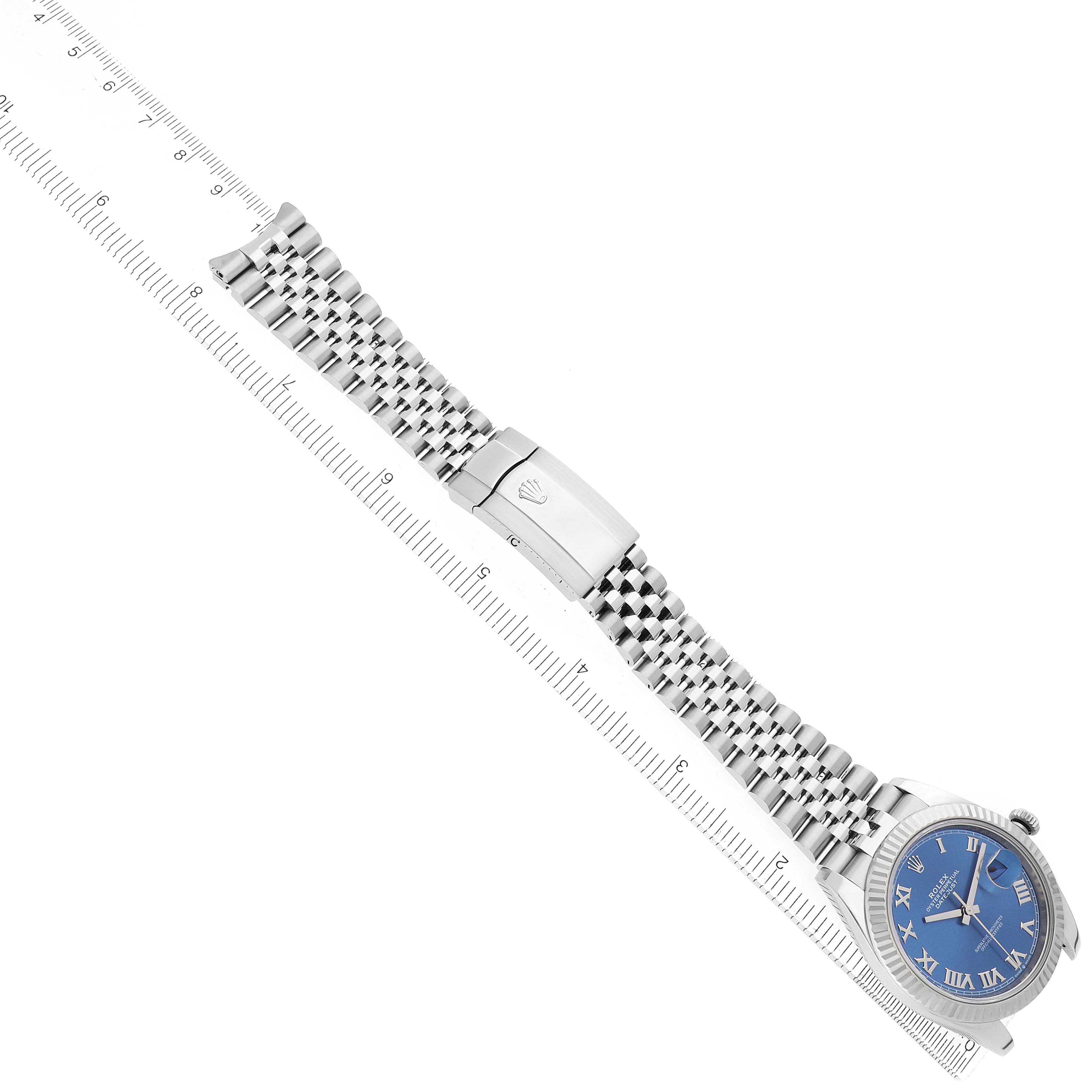 The Rolex Datejust 41 126334 Men
s Stainless Steel Blue Dial is shown diagonally with the full bracelet, clasp, and blue dial visible alongside a ruler.