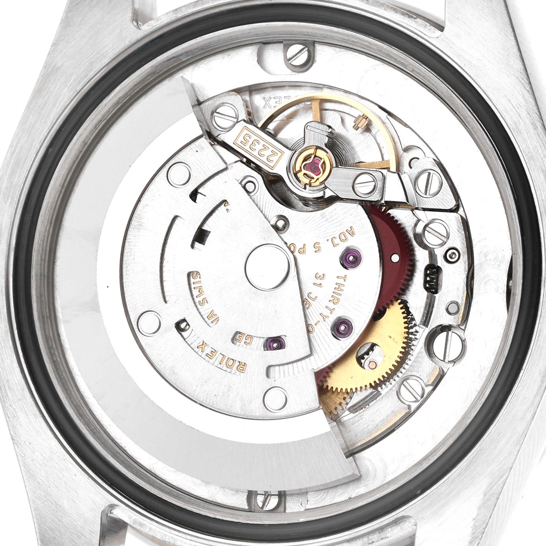 The image shows the inner movement mechanism of a Rolex Datejust 178384 Women's Stainless Steel Blue Dial watch, highlighting gears and the rotor from a rear angle.