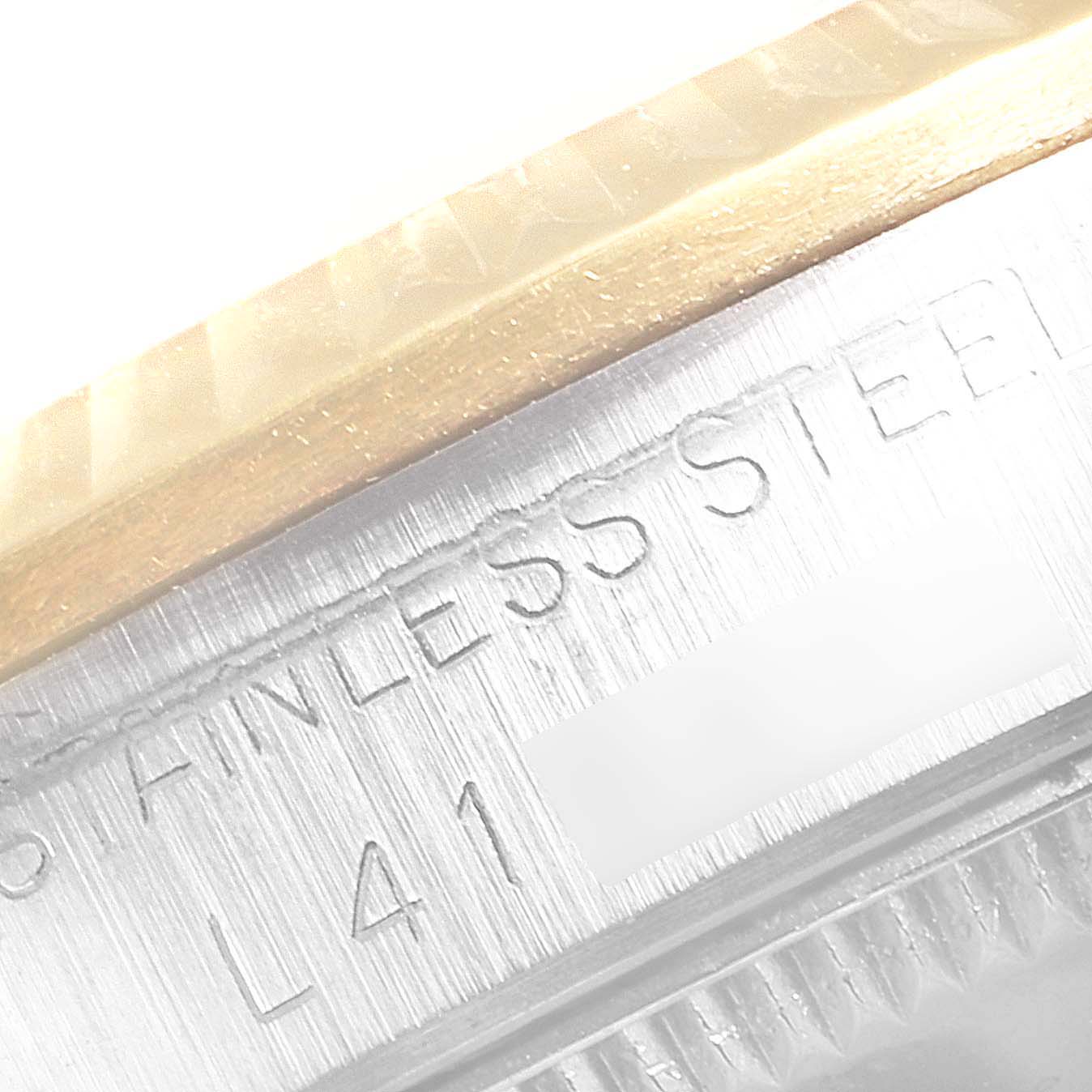 Close-up view of the Rolex Mid-Size 68273 Women
s Steel and Gold (two tone) Black Dial 68273 Women
s Steel and Gold (two tone) Black Dial watch showing part of the bezel and stainless steel case with inscriptions.