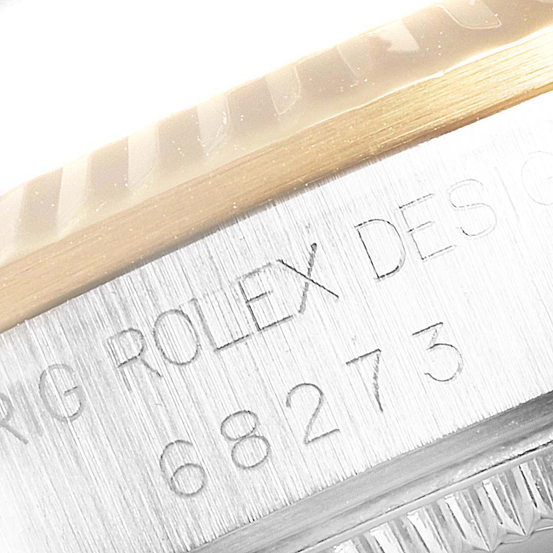 The image shows a close-up of the bezel and engraved serial number on a Rolex Mid-Size 68273 Women
s Steel and Gold (two tone) Champagne Dial 68273 Women
s Steel and Gold (two tone) Champagne Dial watch.