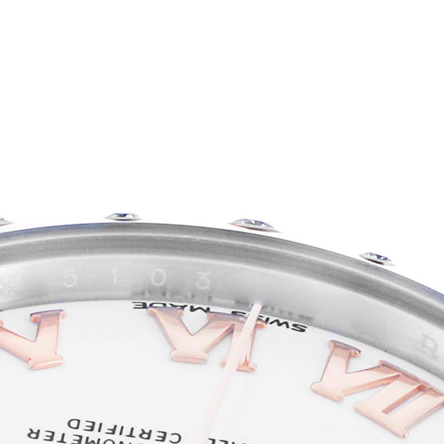 The image shows a close-up of the Rolex Datejust 178341 Women's Steel and Gold (two tone) White Dial watch's dial, featuring the edge of the bezel, a Roman numeral, and some text.