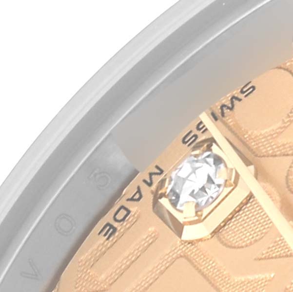 This close-up angle of the Rolex Mid-Size 178273 Women's Steel and Gold (two tone) Champagne Dial 178273 Women's Steel and Gold (two tone) Champagne Dial watch shows a part of the dial, including a diamond marker and the words "SWISS MADE."