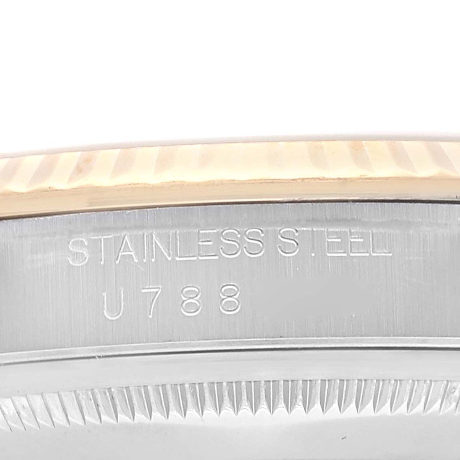 The image shows a close-up of the stainless steel case and fluted bezel of a Rolex Datejust 16233 Men's Steel and Gold (two tone) Champagne Dial 16233 Men's Steel and Gold (two tone) Champagne Dial model watch with an engraved serial number.