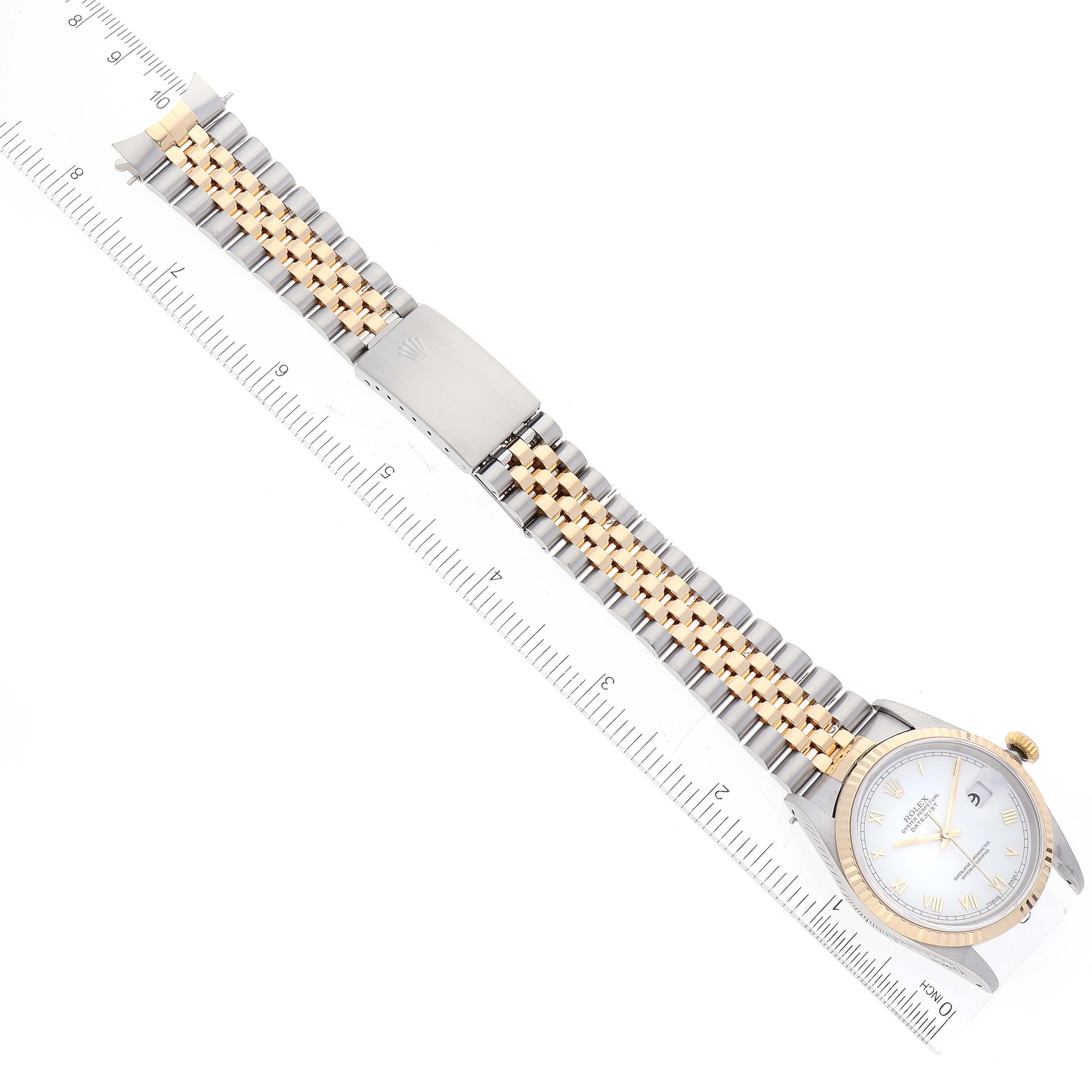 The image shows a Rolex Datejust 16233 Men's Steel and Gold (two tone) White Dial 16233 Men's Steel and Gold (two tone) White Dial watch laid flat with its full band and face visible next to a ruler for scale.