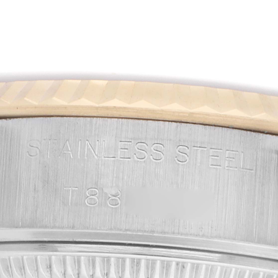 The image shows a close-up of the side engraving on a Rolex Datejust 69173 Women's Steel and Gold (two tone) Champagne Dial bezel, displaying "STAINLESS STEEL."