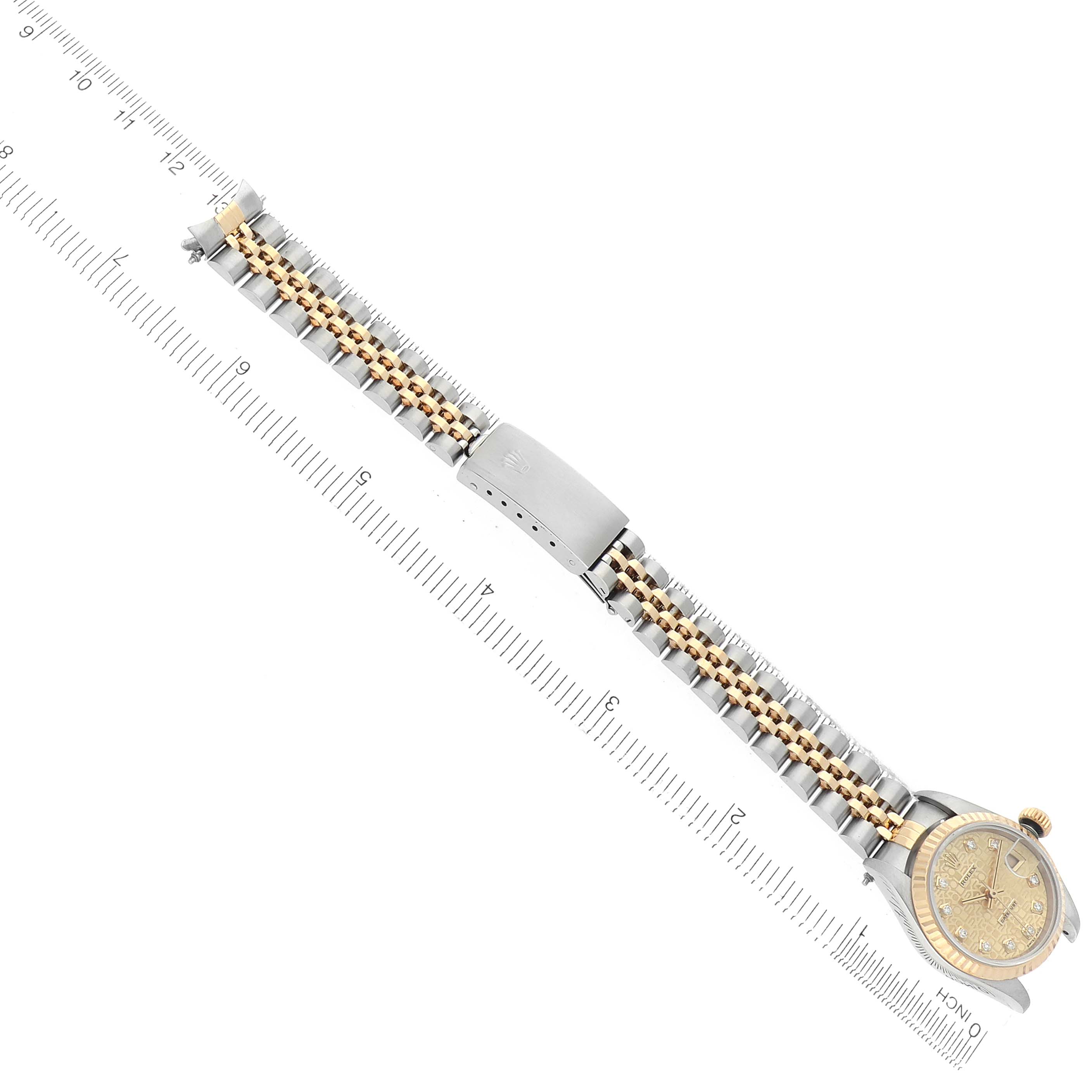 The Rolex Datejust 69173 Women's Steel and Gold (two tone) Champagne Dial watch is shown diagonally, featuring the face, bracelet, and clasp, with a ruler alongside for scale.