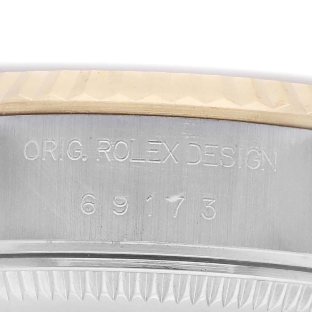 The image shows the side of a Rolex Datejust 69173 Women's Steel and Gold (two tone) Champagne Dial case, highlighting the model engraving and part of the bezel.