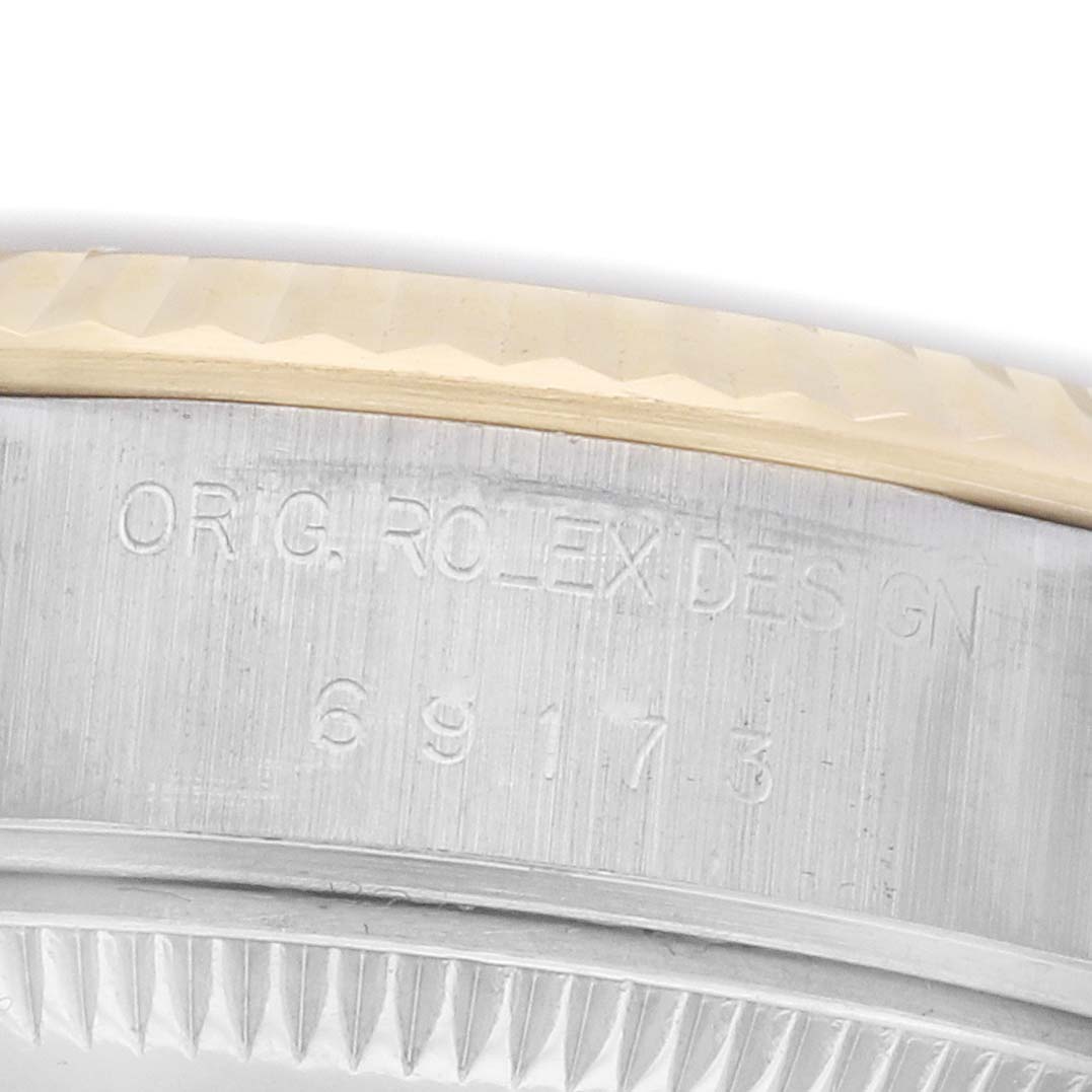 The image shows a close-up of the engraved case side of a Rolex Datejust 69173 Women's Steel and Gold (two tone) Champagne Dial, highlighting the model number and brand engraving.