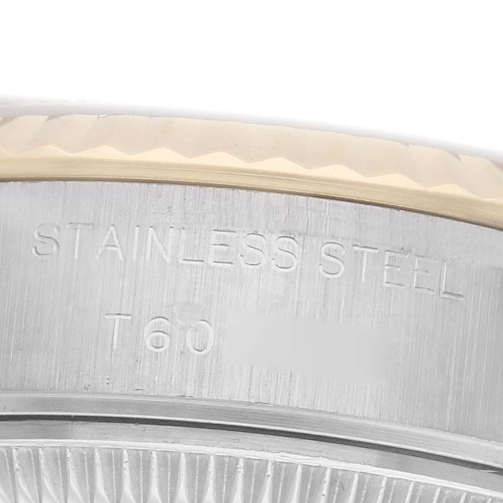 The image shows the edge and case side of a Rolex Datejust 69173 Women's Steel and Gold (two tone) Silver Dial, highlighting the engraving and fluted bezel.